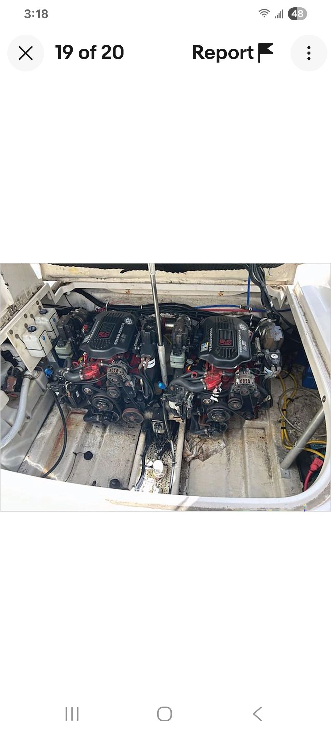 Two engines in a boat's engine compartment, surrounded by cables and hoses.