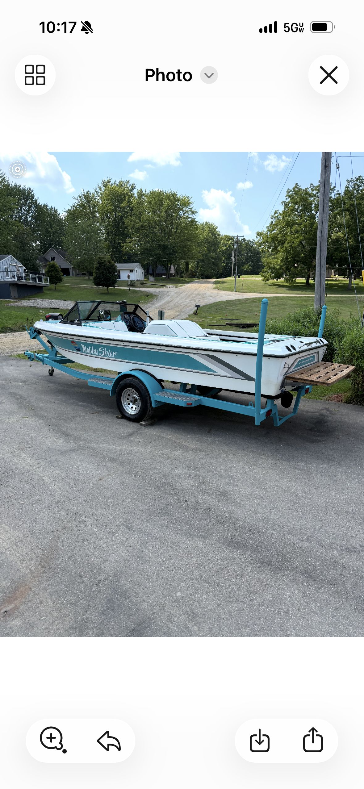 A 1992 Malibu Skier on a trailer, parked on a street in a residential area.
