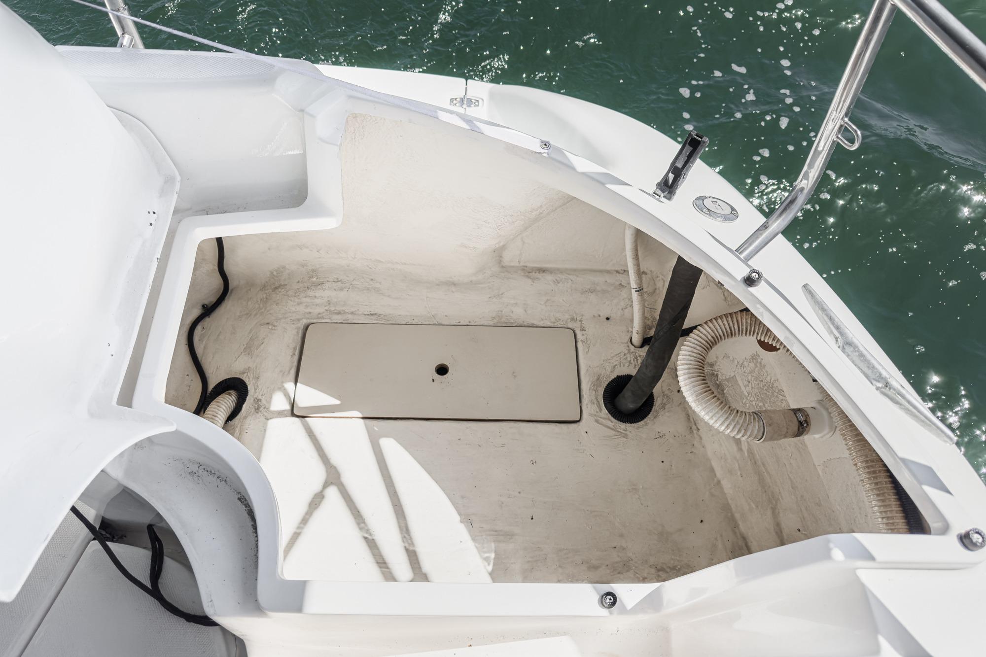 Cockpit area of a 1996 Hunter 376 sailboat, showing storage and water access.