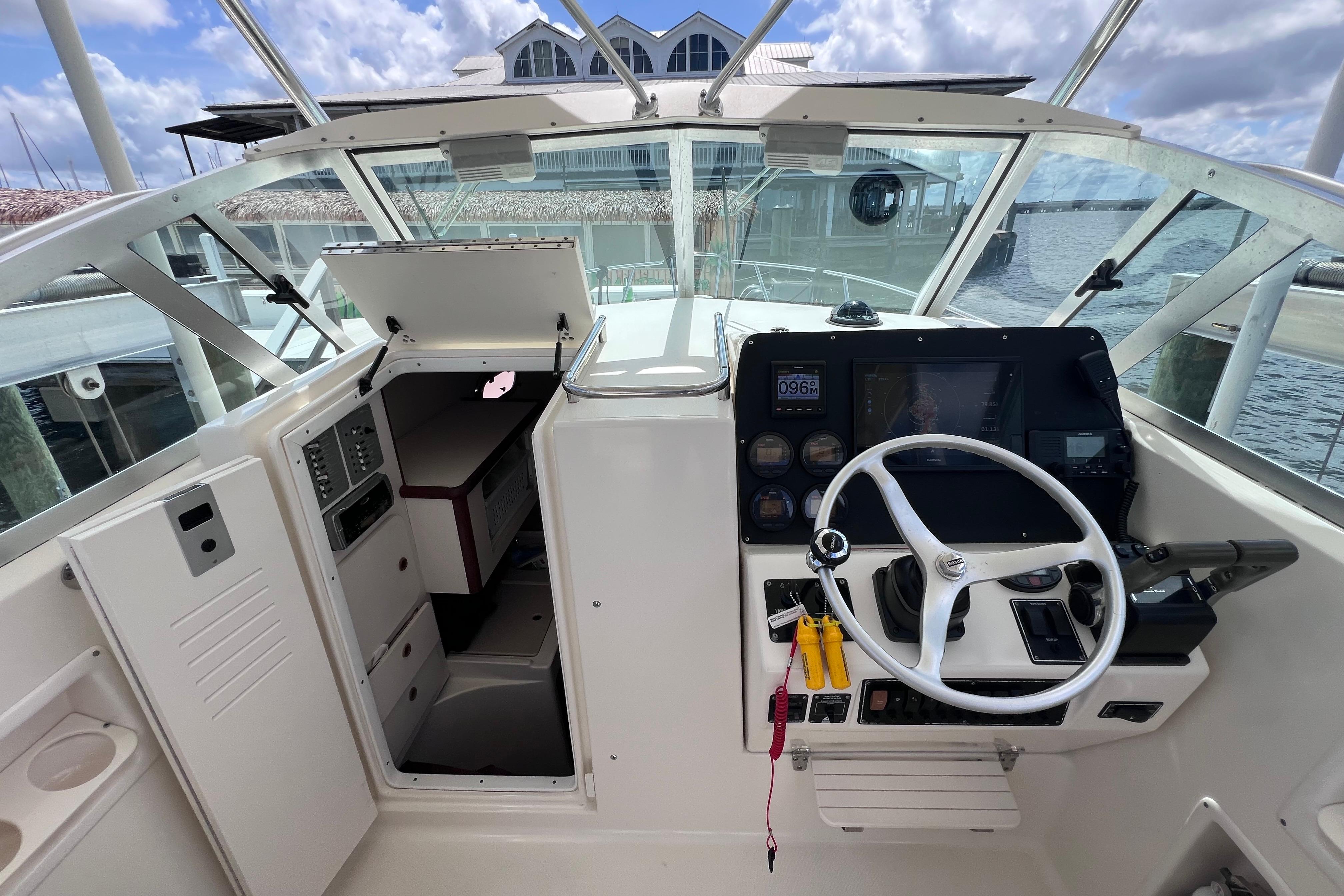 2004 Pursuit 2870 Walkaround boat interior with steering wheel and cabin access.