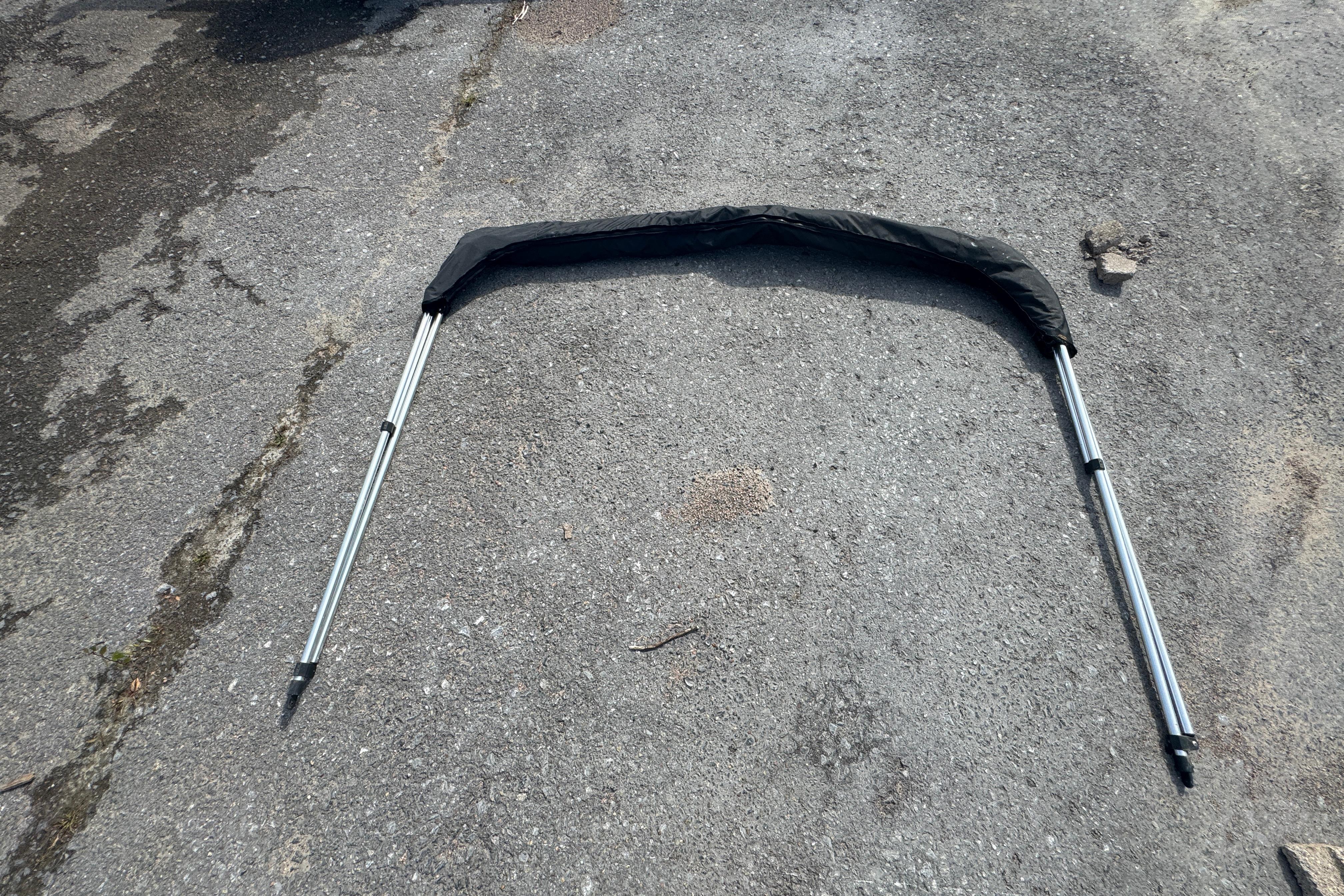 Folded bimini top frame on pavement, suitable for 2007 Trophy 1703 Center Console boat.