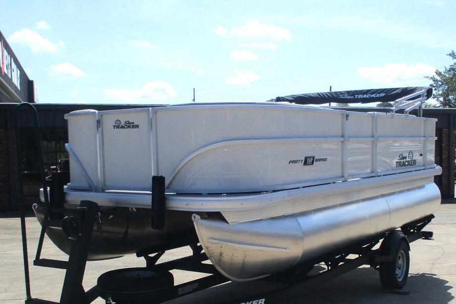 2026 Sun Tracker Party Barge 18 DLX pontoon boat on trailer, parked outdoors.