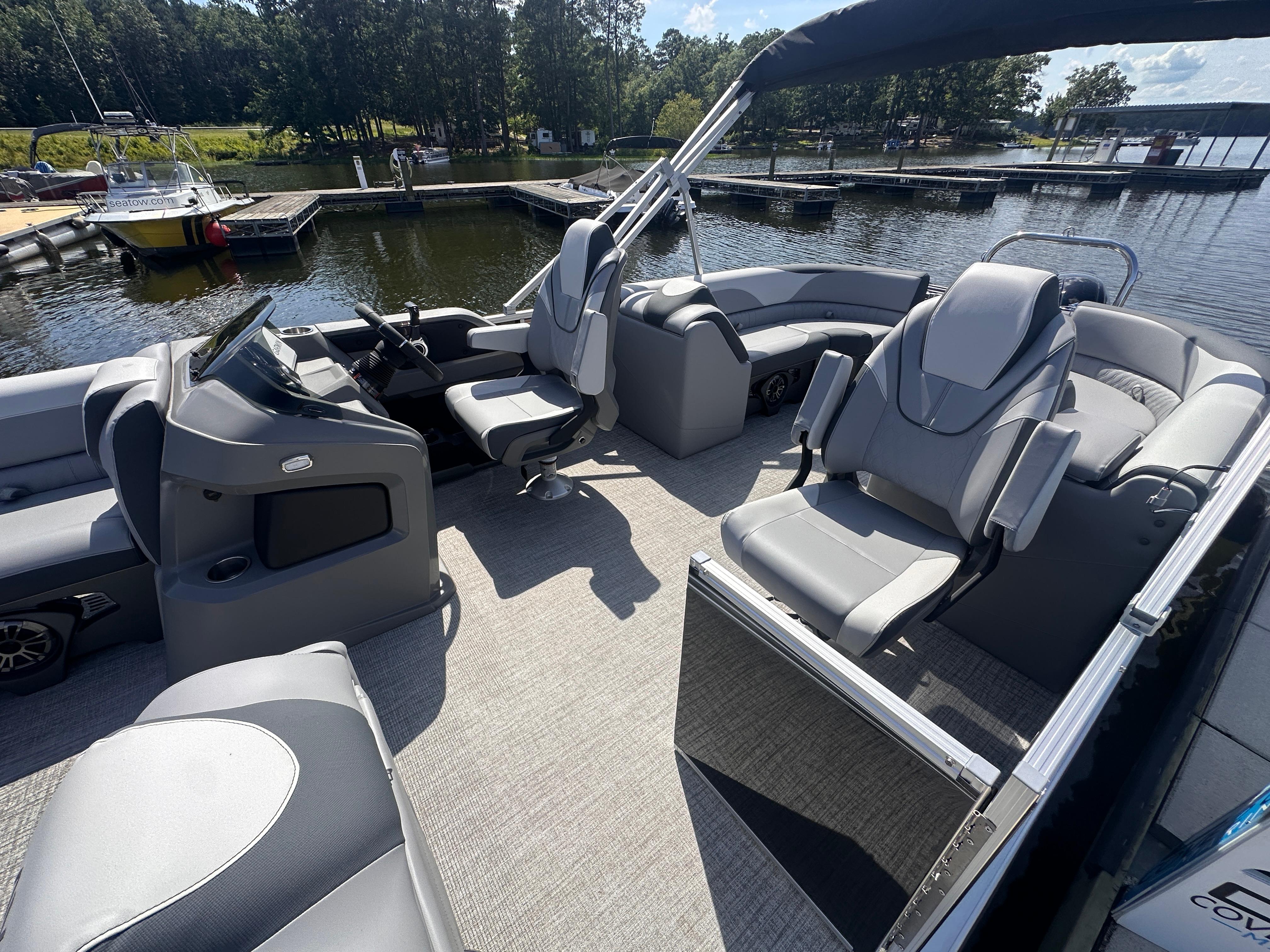 2025 Avalon LSZ Quad Lounger pontoon boat interior with luxurious seating at a marina.