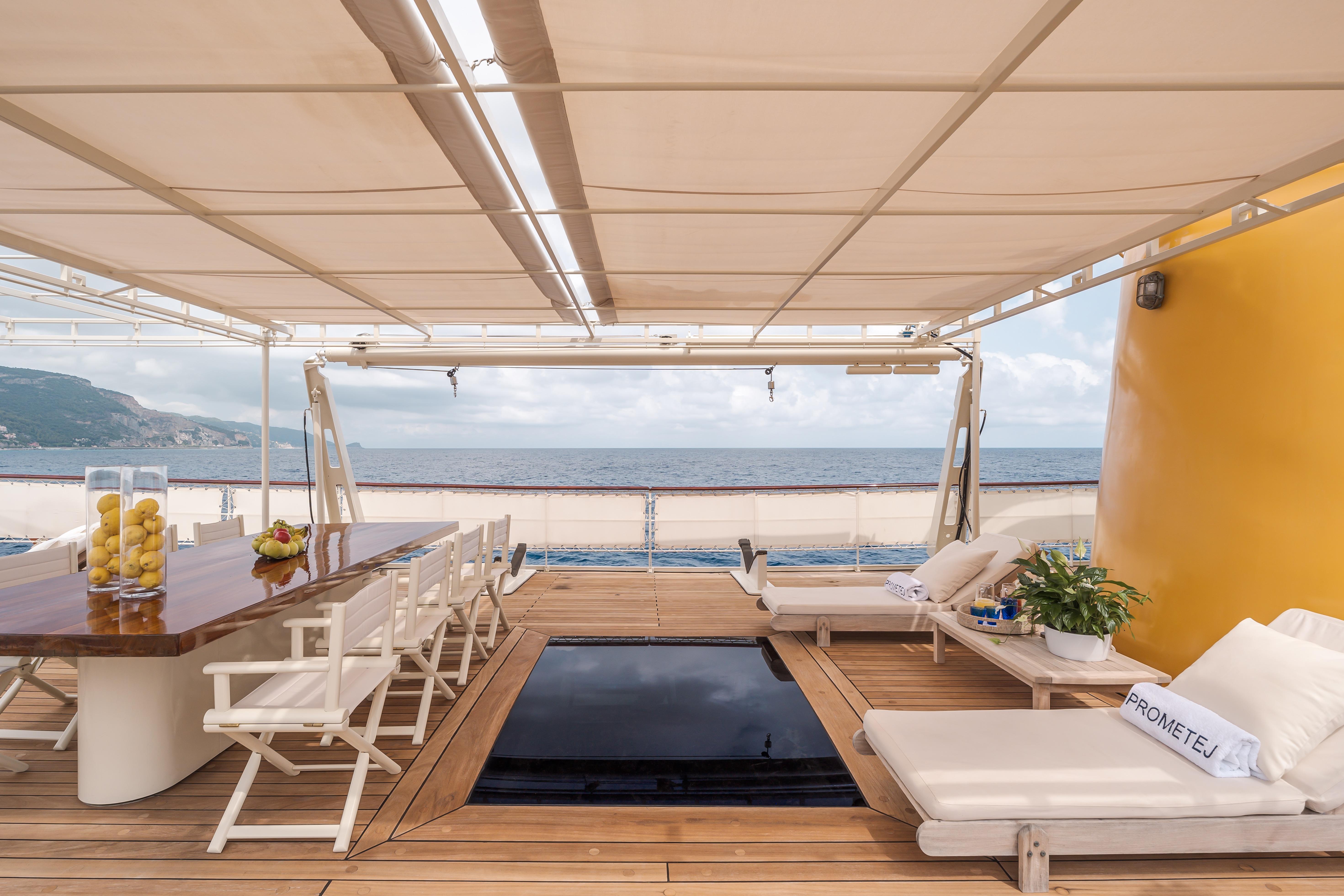 Luxurious deck of a 1956 custom converted tugboat with seating and ocean view.