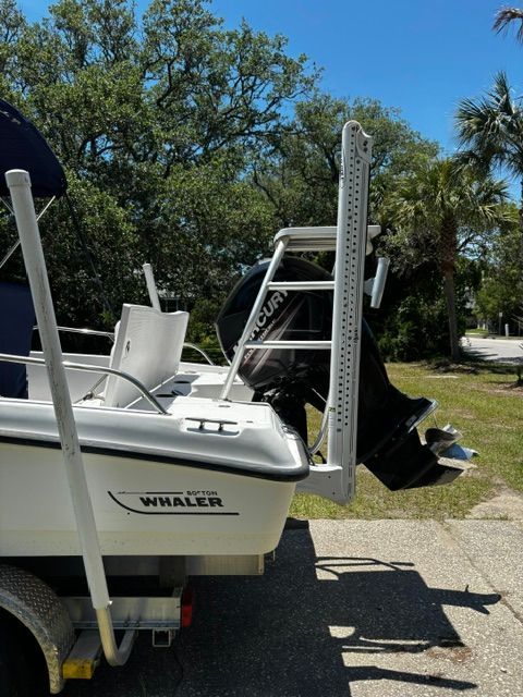 A 2008 Boston Whaler 200 Dauntless on a trailer, surrounded by trees.