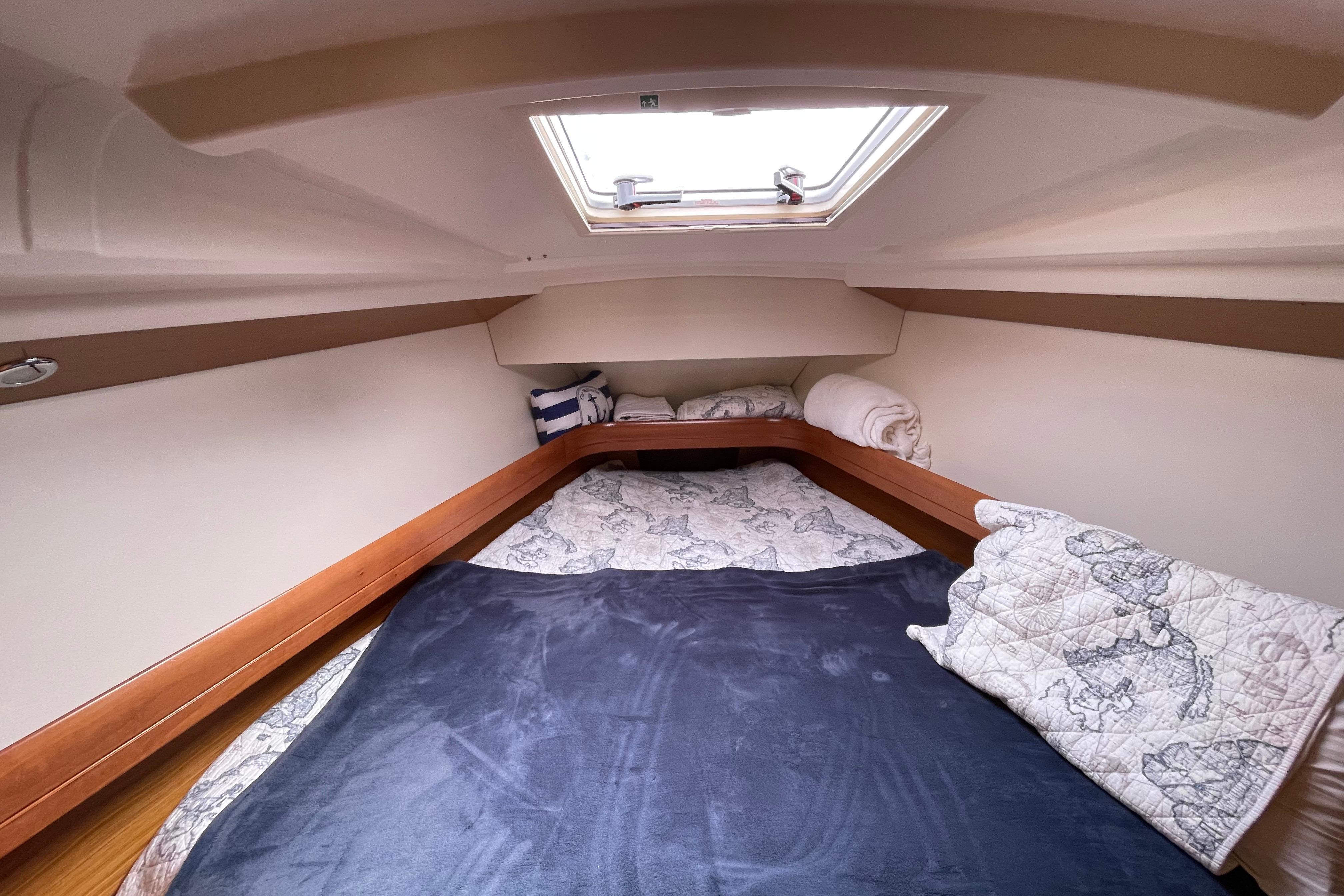 Cozy cabin interior of 2007 Jeanneau Sun Odyssey 39 DS sailboat with bedding and skylight.