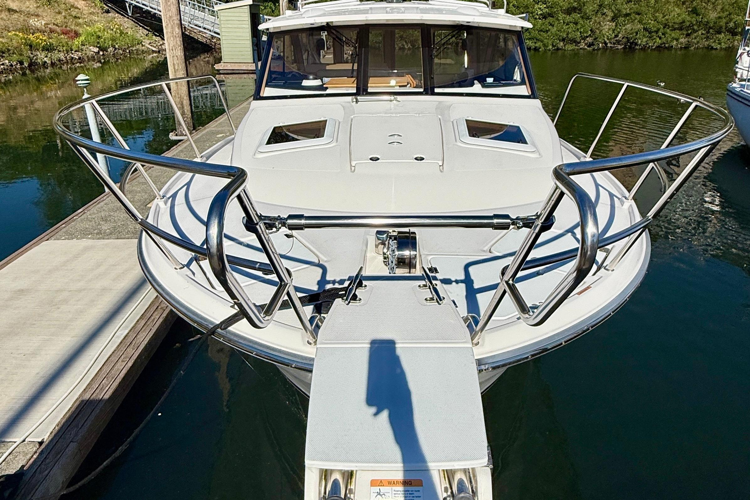 2023 Cutwater C-30 Sedan boat docked, front view with stainless steel railings.