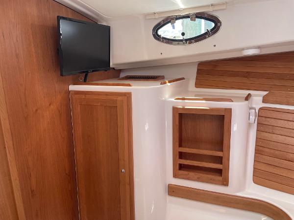 2024 Back Cove 34O interior cabin with wooden cabinetry and mounted TV.