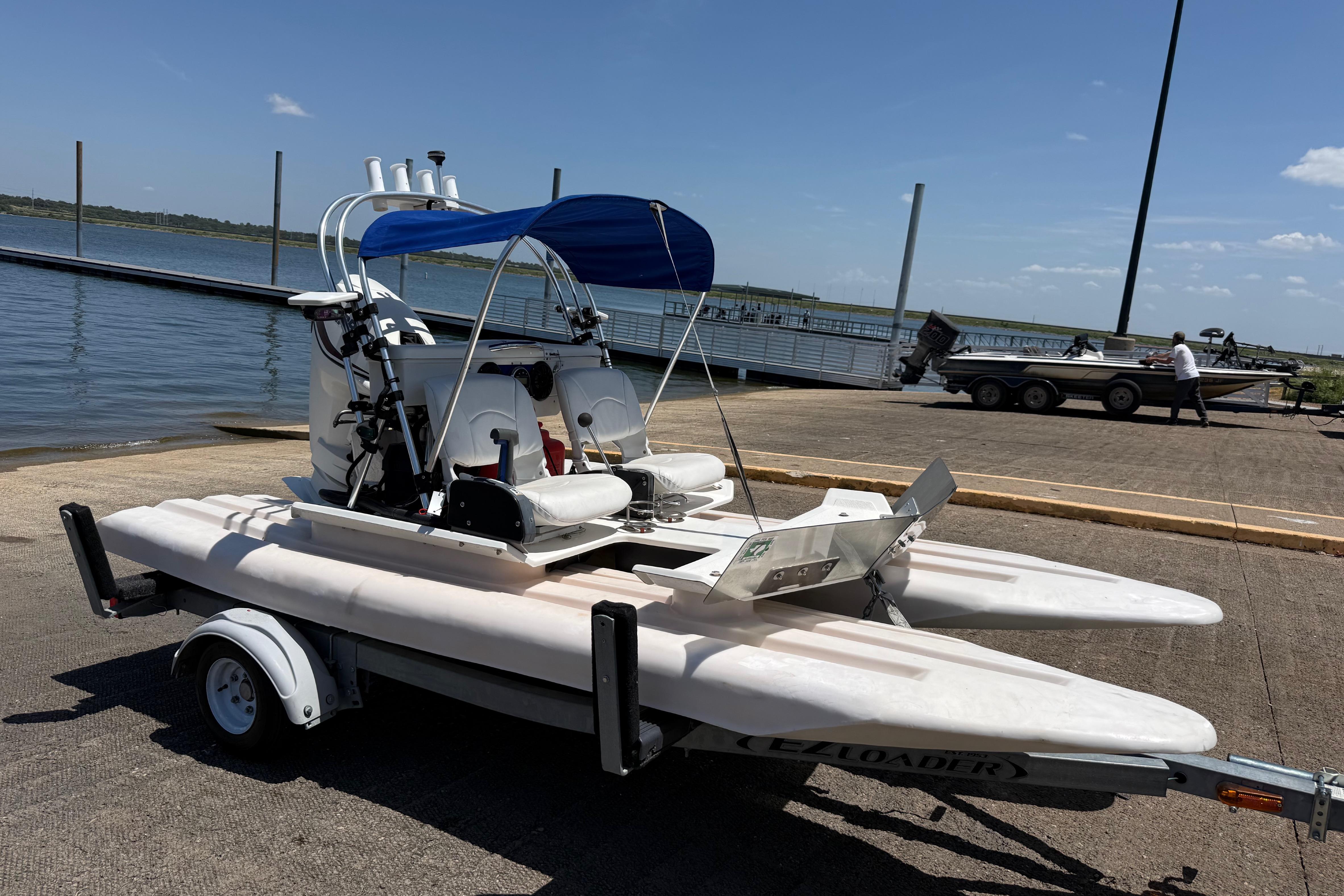2016 CraigCat E2 Elite on trailer by lakeside dock under clear sky.