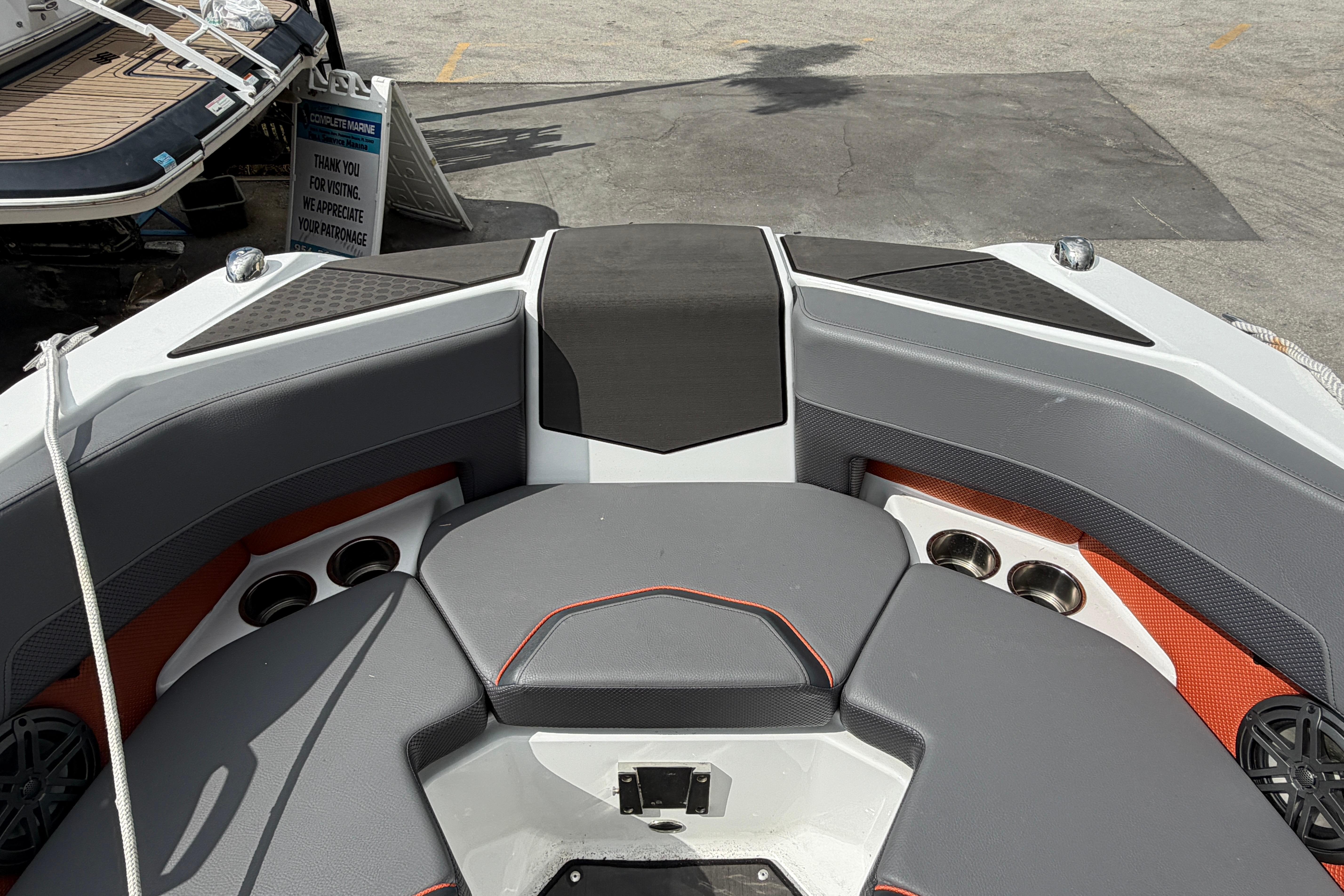 Bow seating area of 2026 Scarab 235 LX boat with cup holders and speakers.