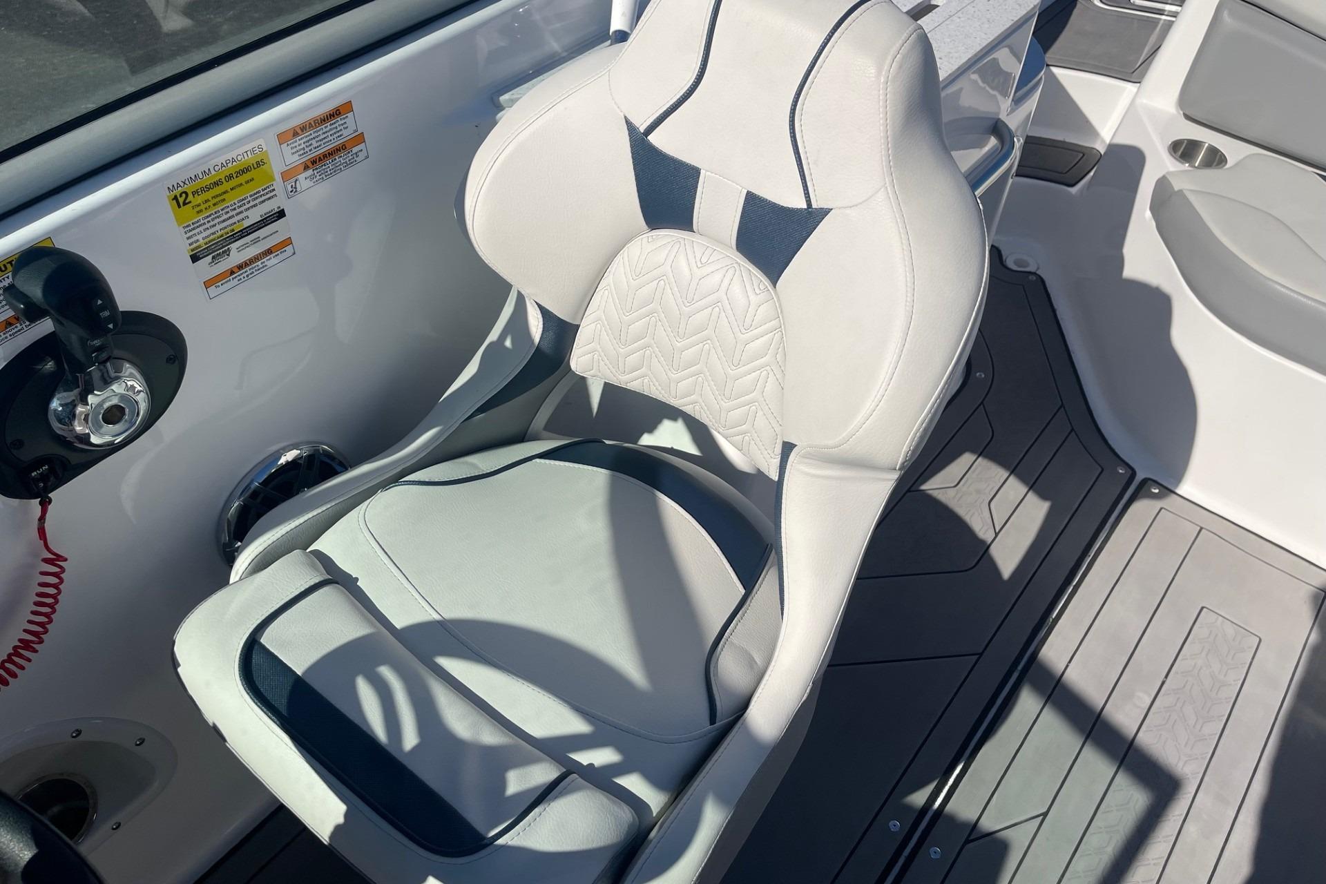 Captain's chair on 2023 Hurricane SunDeck 2400 OB boat, featuring sleek design and controls.