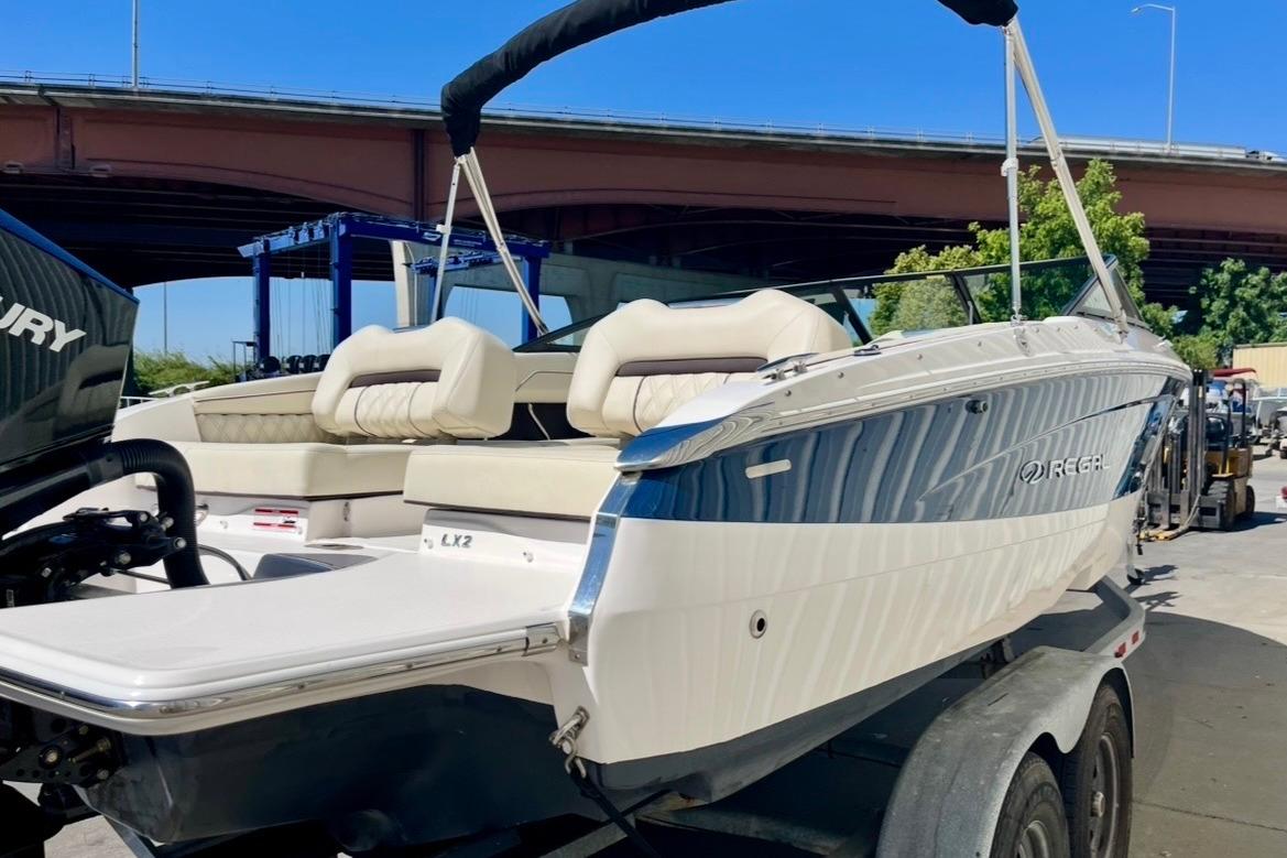 2025 Regal LX2 boat with sleek design, parked on a trailer under a bridge.