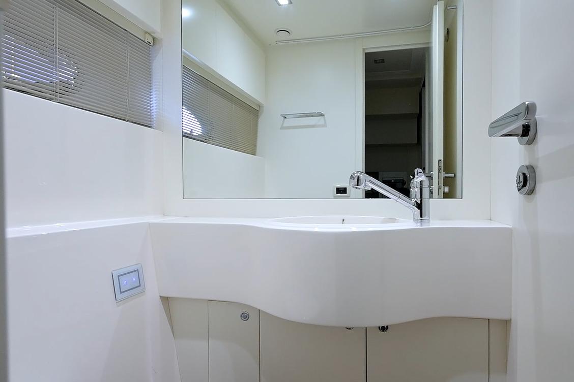 Modern bathroom interior on a 2015 Pershing 92 yacht, featuring sleek white fixtures.