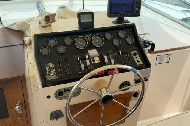 1980 Chris-Craft 381 Catalina helm with gauges, steering wheel, and navigation equipment.