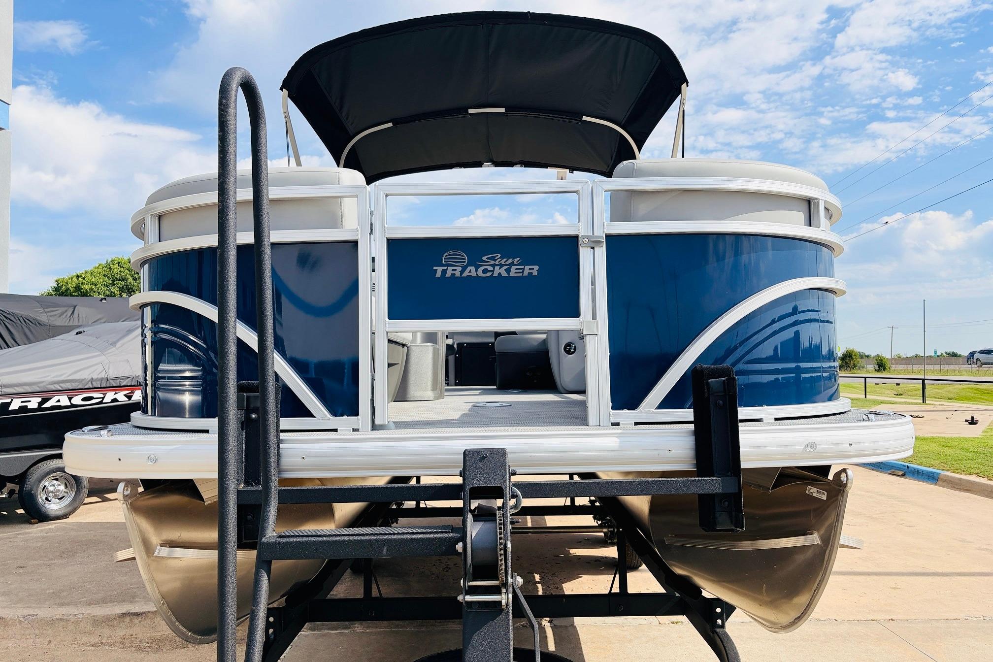 2026 Sun Tracker SportFish 22 DLX pontoon boat on trailer, blue and white design.