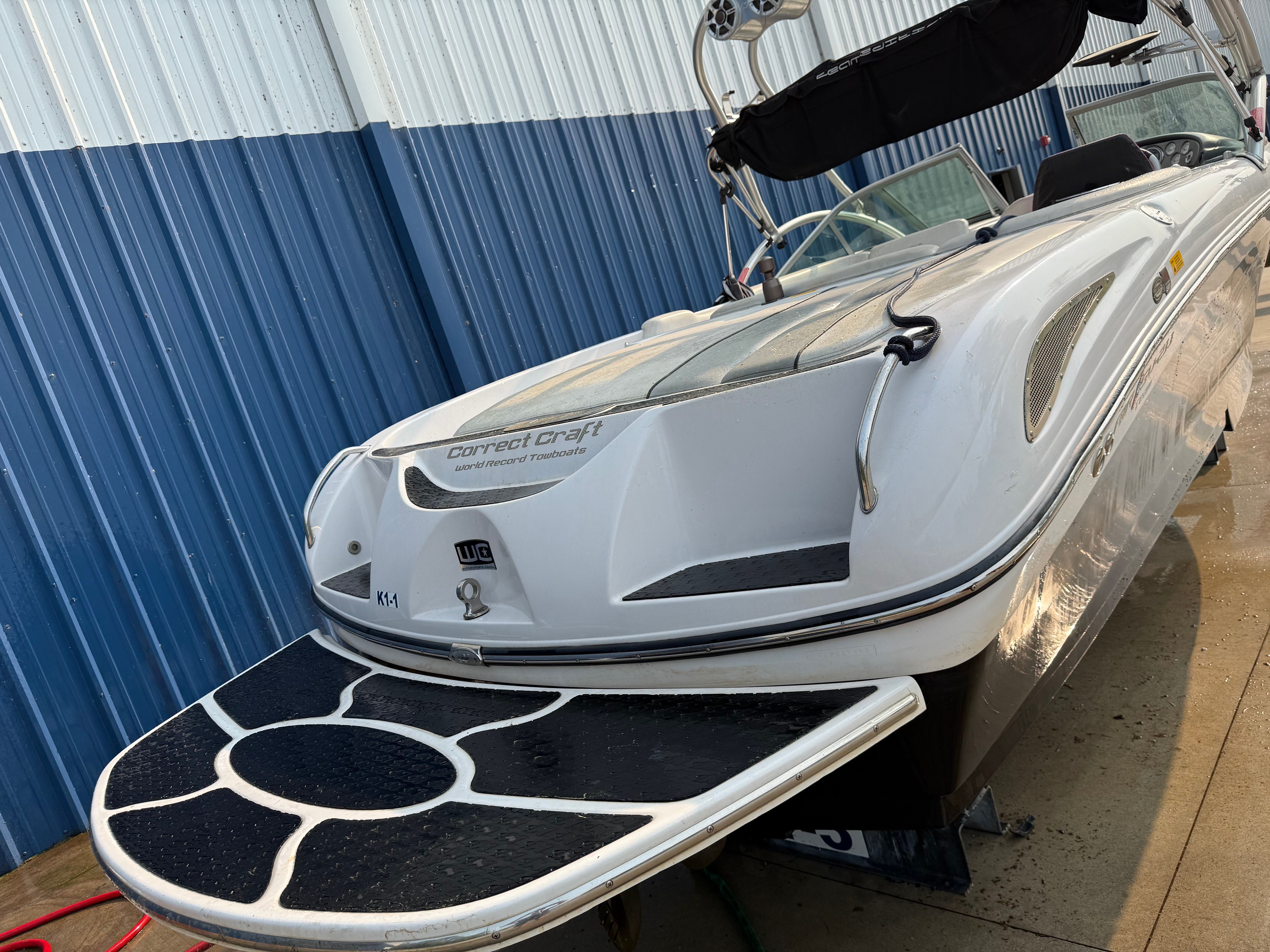 2007 Nautique SV 211 with sleek design and spacious deck, parked on land.