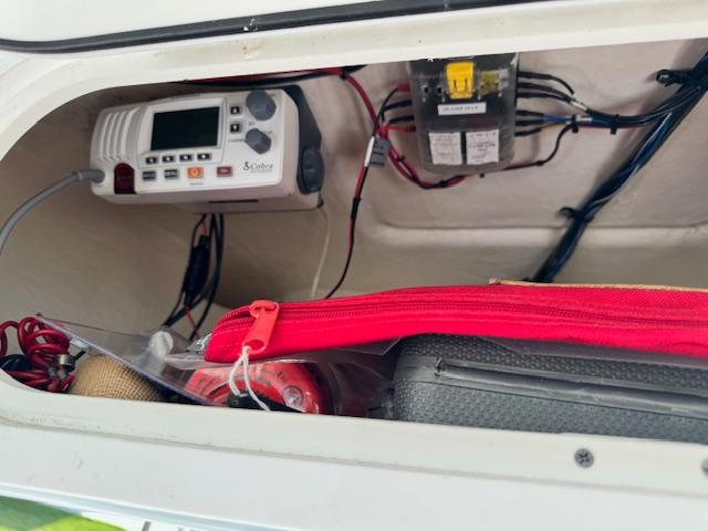 2013 Sea Fox 286 CC storage compartment with electronic equipment and red zippered bag.