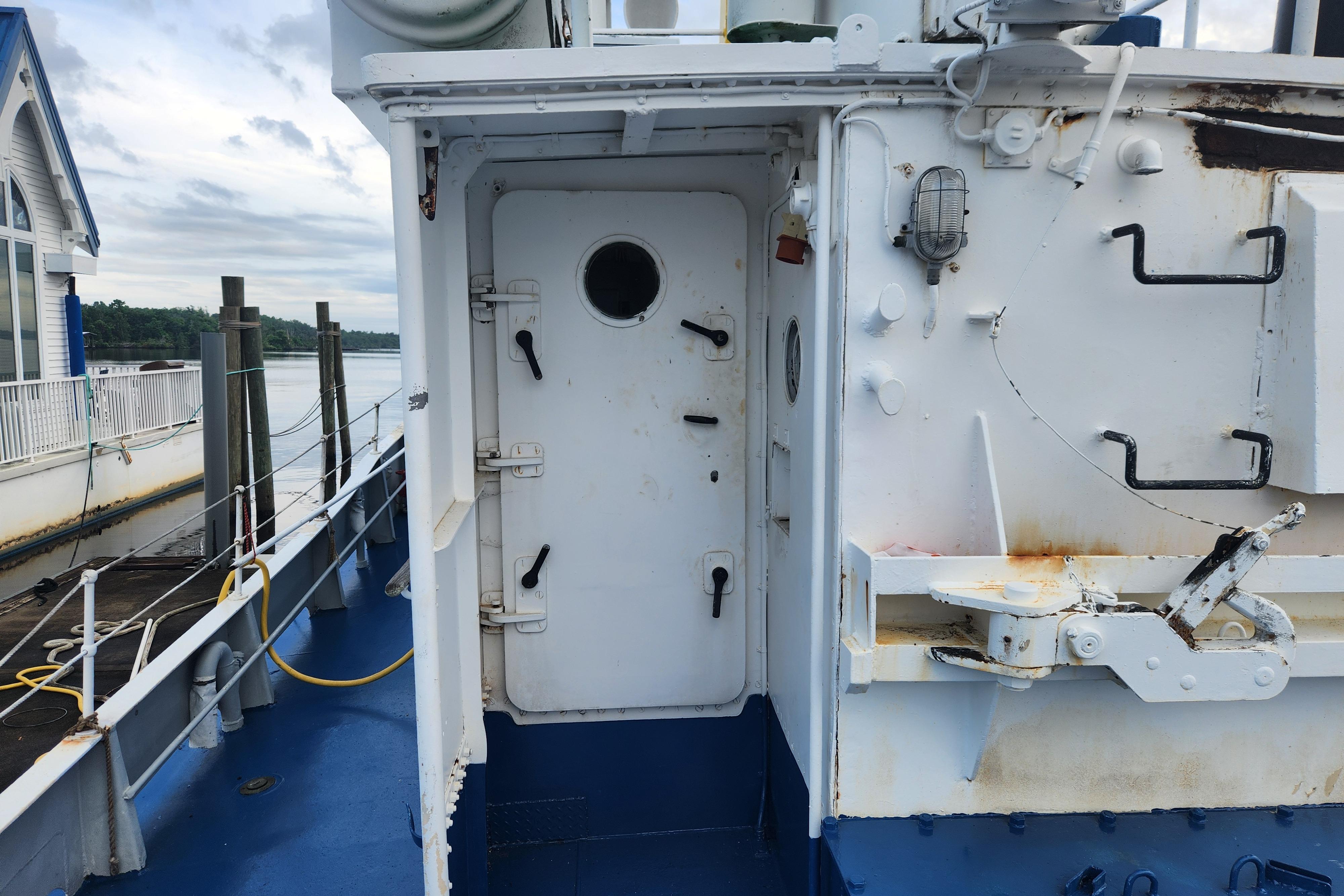 Exterior view of a 1960 Stord Verft 60 ship, featuring a white door and nautical equipment.