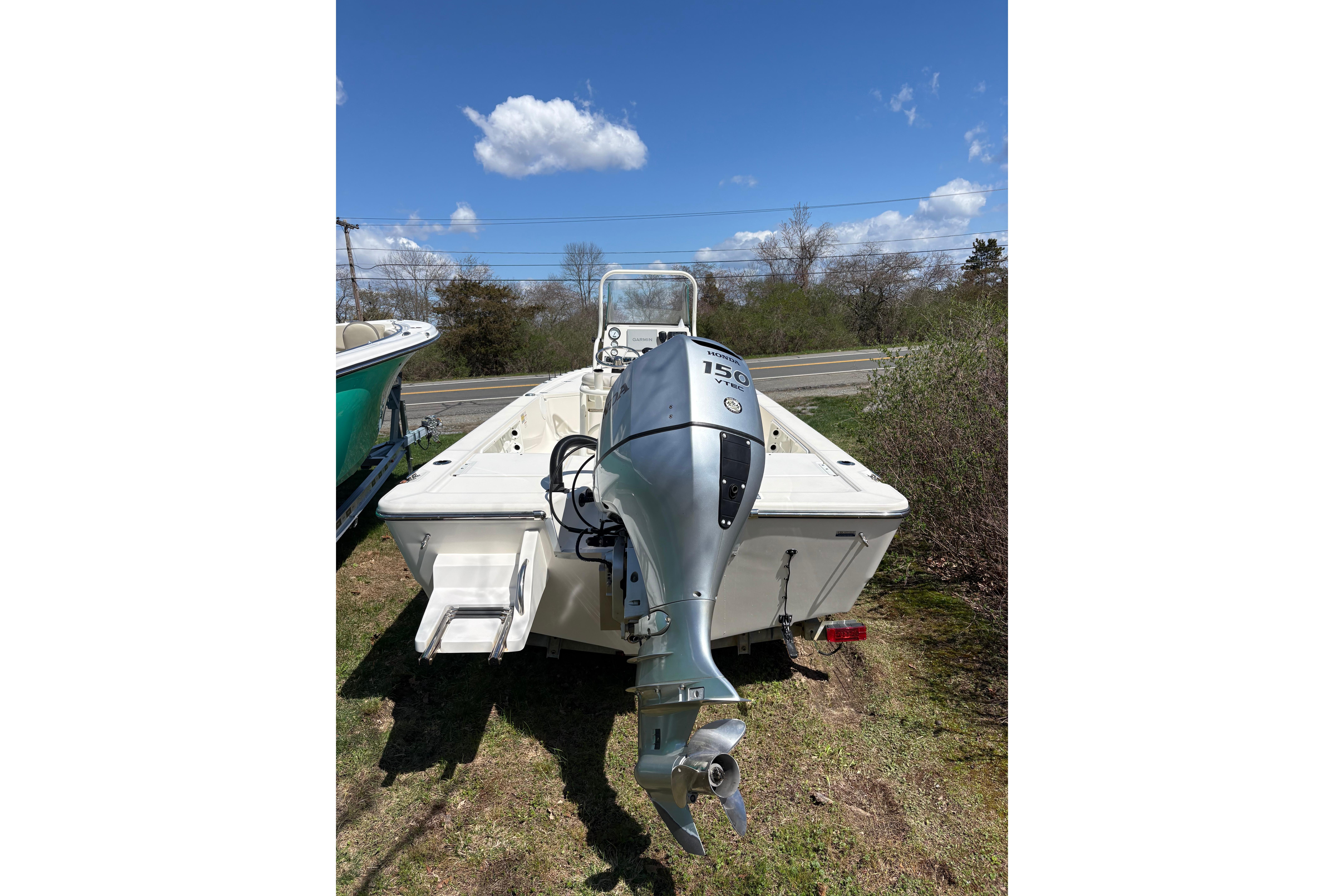 2021 Sea Born FX21 Bay boat with Honda 150 outboard motor, parked outdoors.