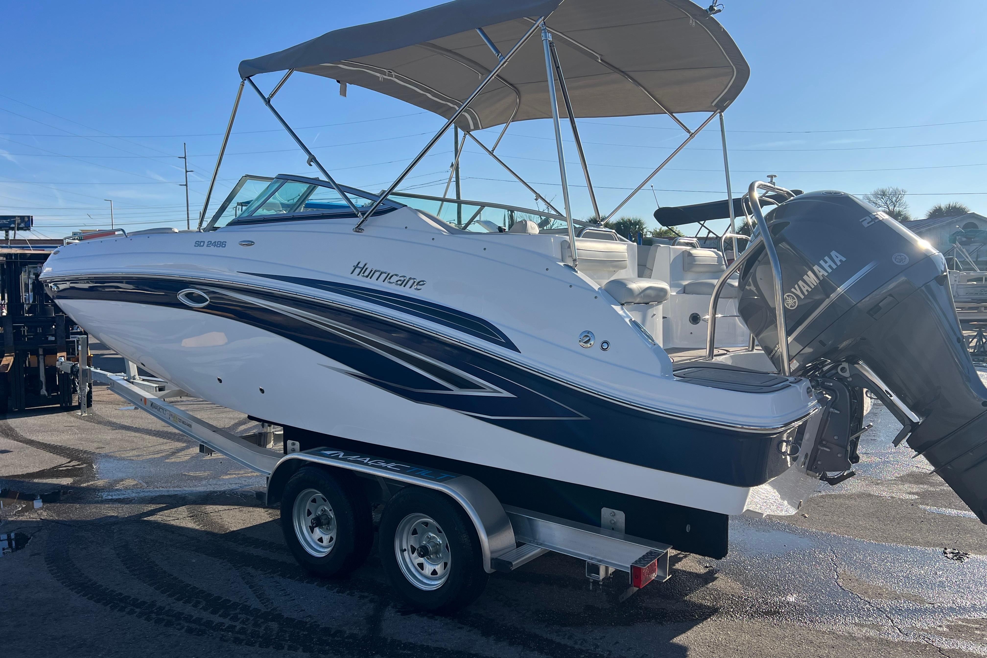 2026 Hurricane SunDeck 2486 OB boat on trailer with Yamaha outboard motor.