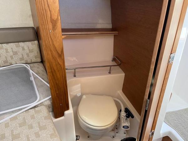 2025 Cutwater C-248 C Coupe boat interior with compact bathroom and toilet.
