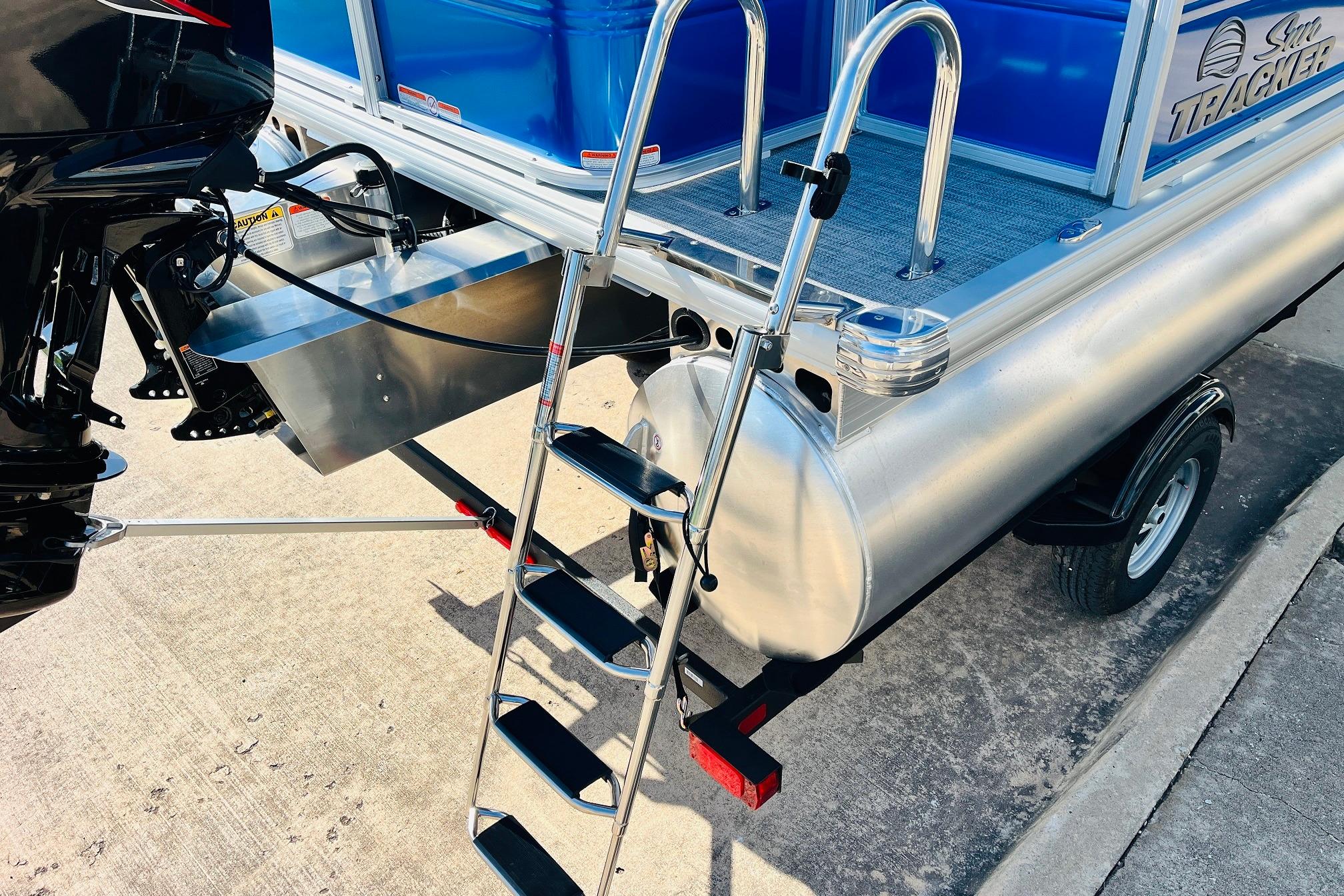 2026 Sun Tracker Party Barge 18 DLX pontoon boat with motor and boarding ladder.