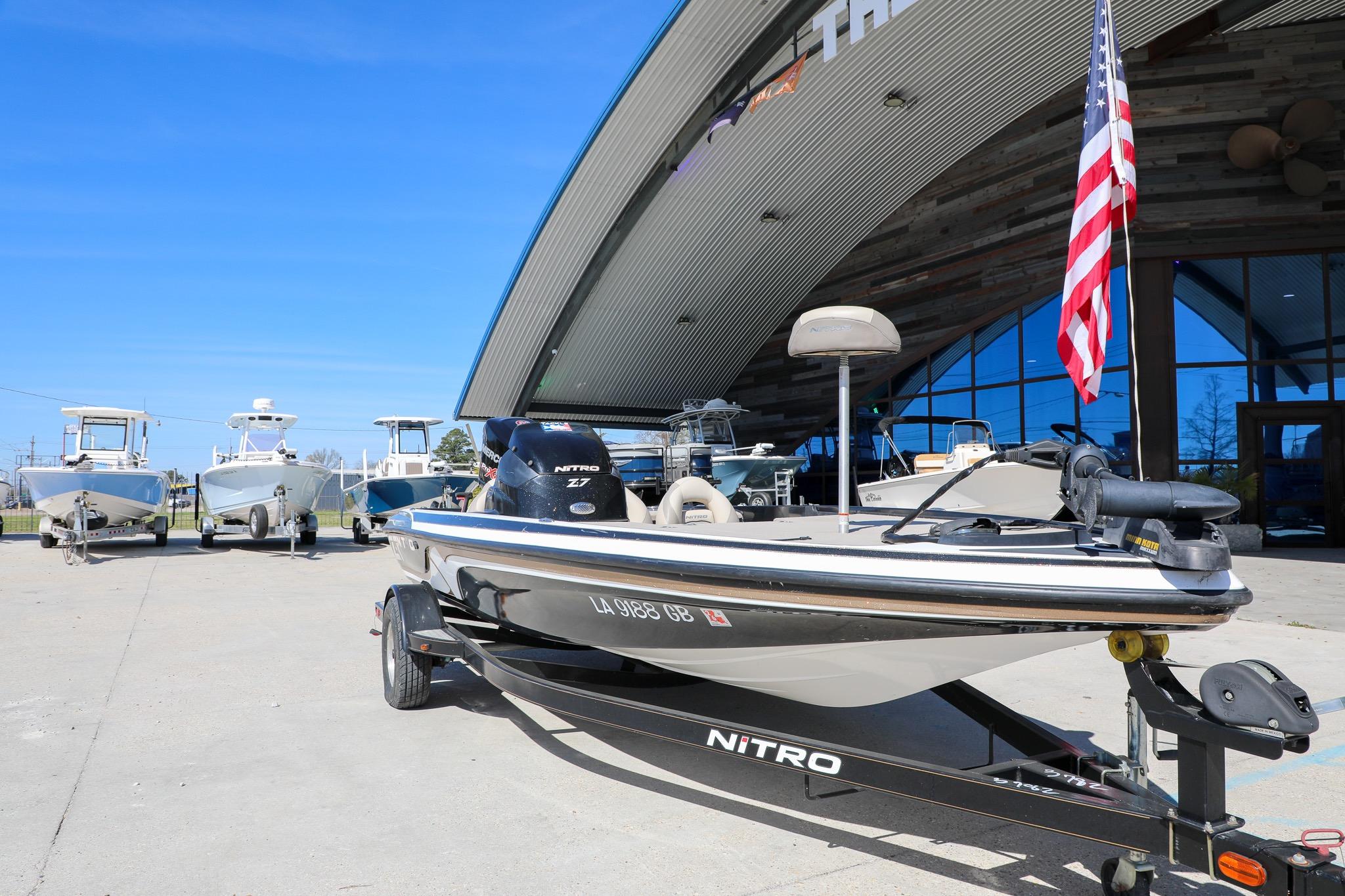 2013 Nitro Z-7 boat on trailer outside dealership with American flag.
