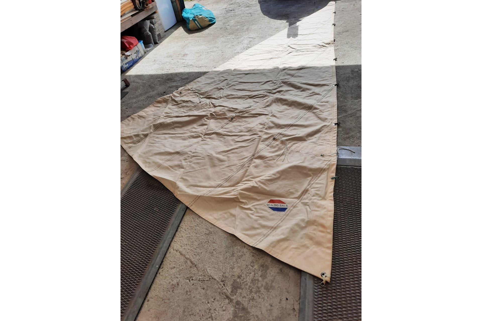 Beige sail for Friesian Tjotter boat, laid out on concrete floor, 2006 model.