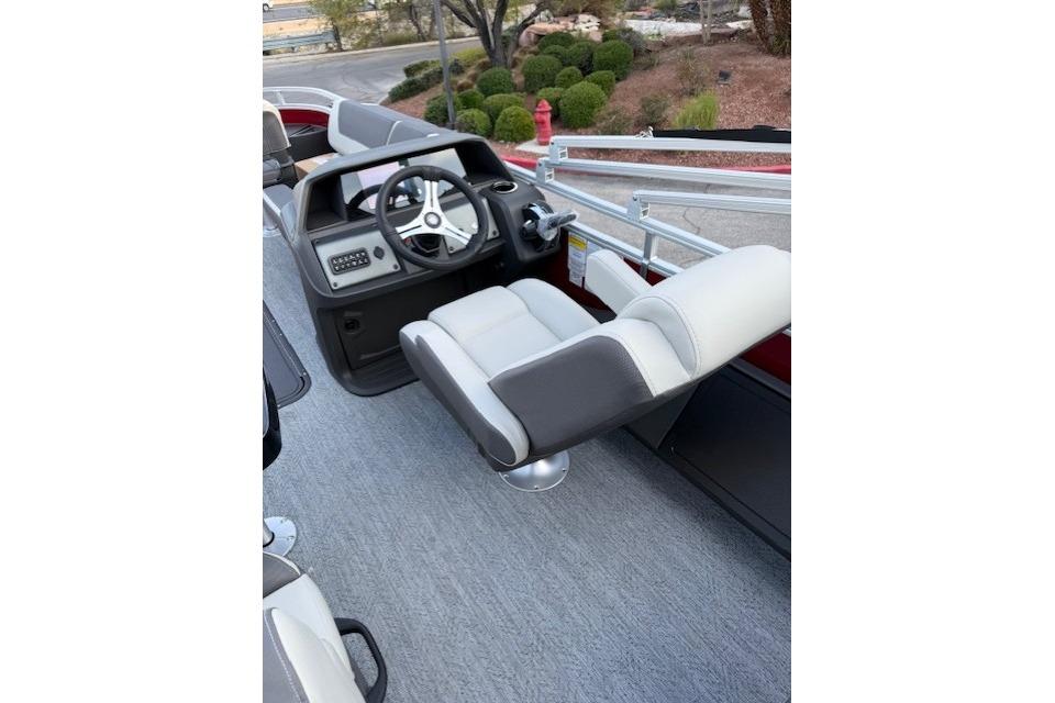 2026 Sun Tracker Fishin' Barge 22 XP3 interior with steering wheel and seating.