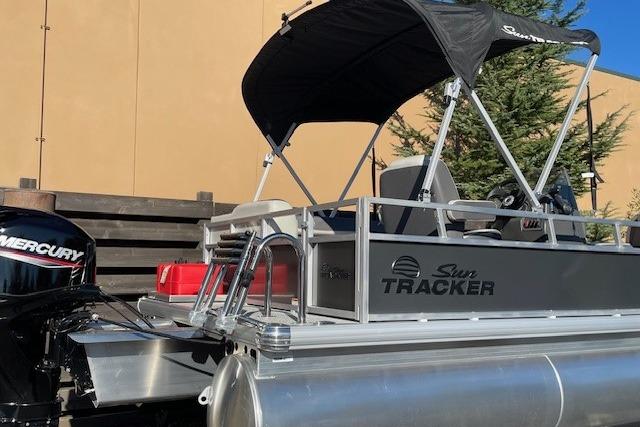 2026 Sun Tracker Bass Buggy 16 XL Select pontoon boat with Mercury engine and canopy.