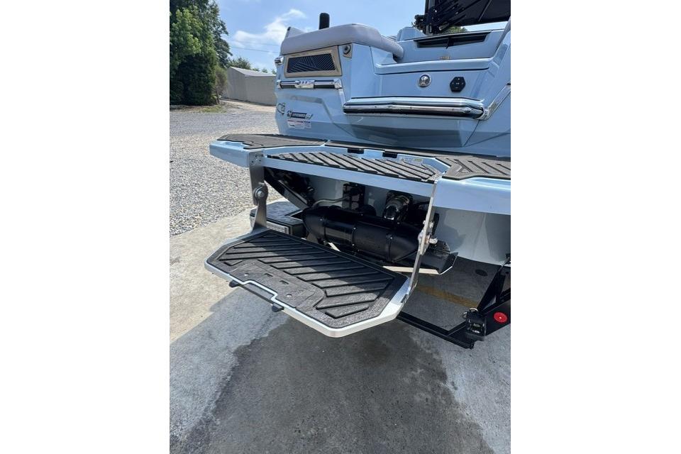 Rear view of 2026 MasterCraft XStar 25 boat with swim platform and step.