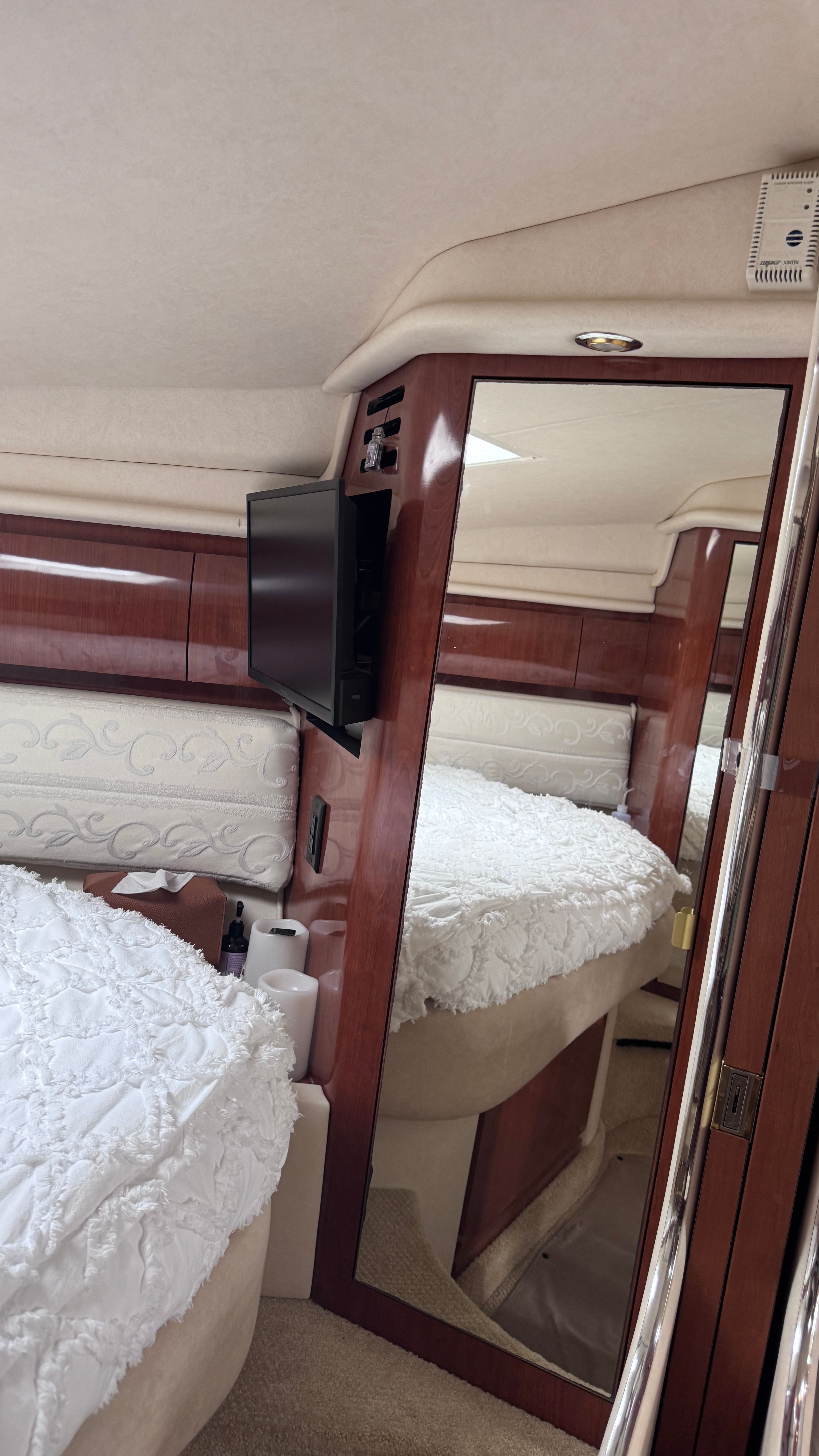 Interior of the 2003 Sea Ray 360 Sundancer with bed and mirror.