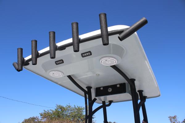 2025 East Cape 25 Open boat T-top with rod holders against clear blue sky.