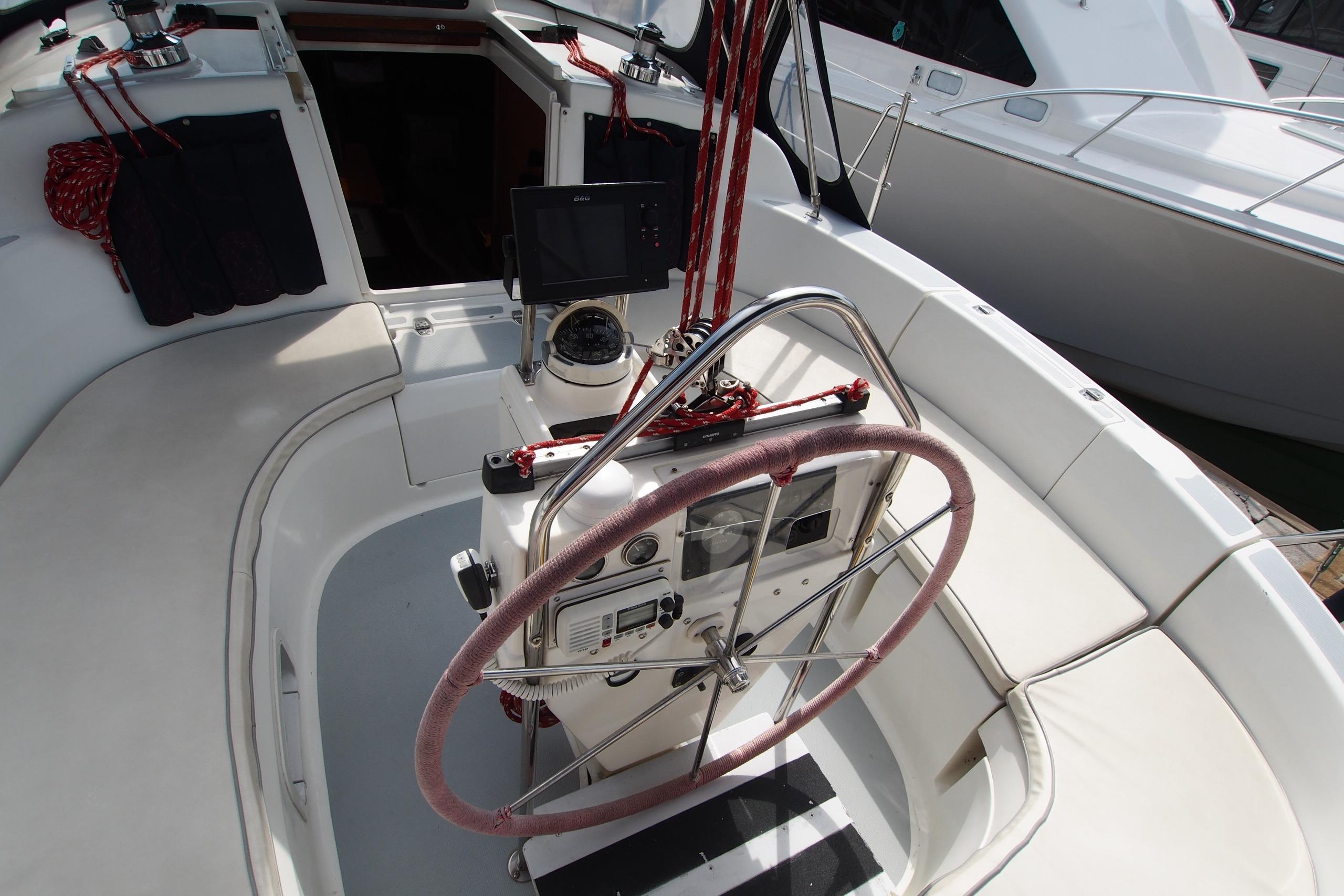 Cockpit of a 1995 Hunter 336 sailboat with steering wheel and navigation equipment.