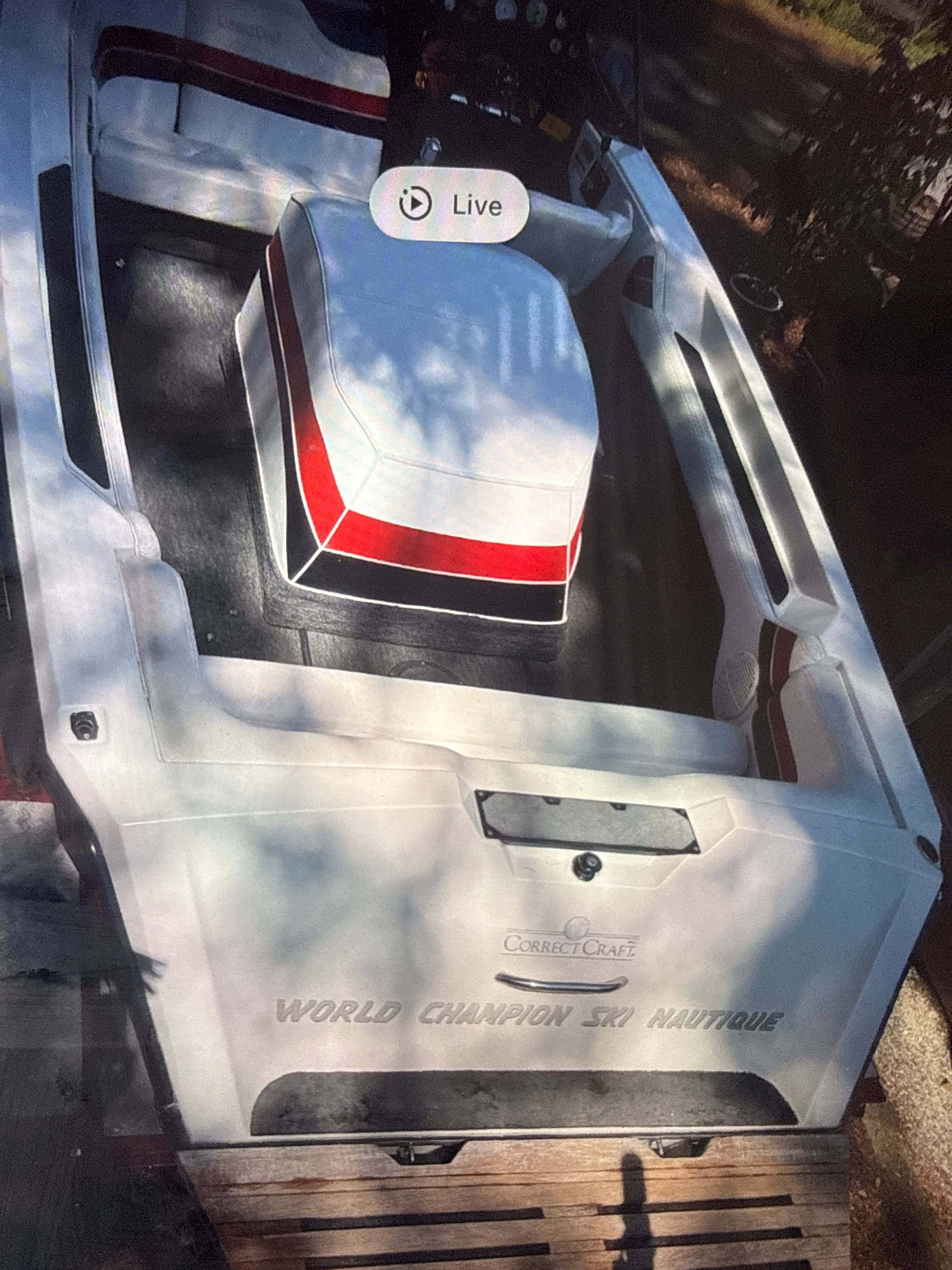 1990 Correct Craft Ski Nautique boat with red stripe.