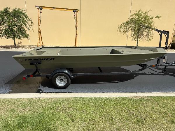 2025 Tracker GRIZZLY 1860 Utility boat on trailer, parked outdoors.