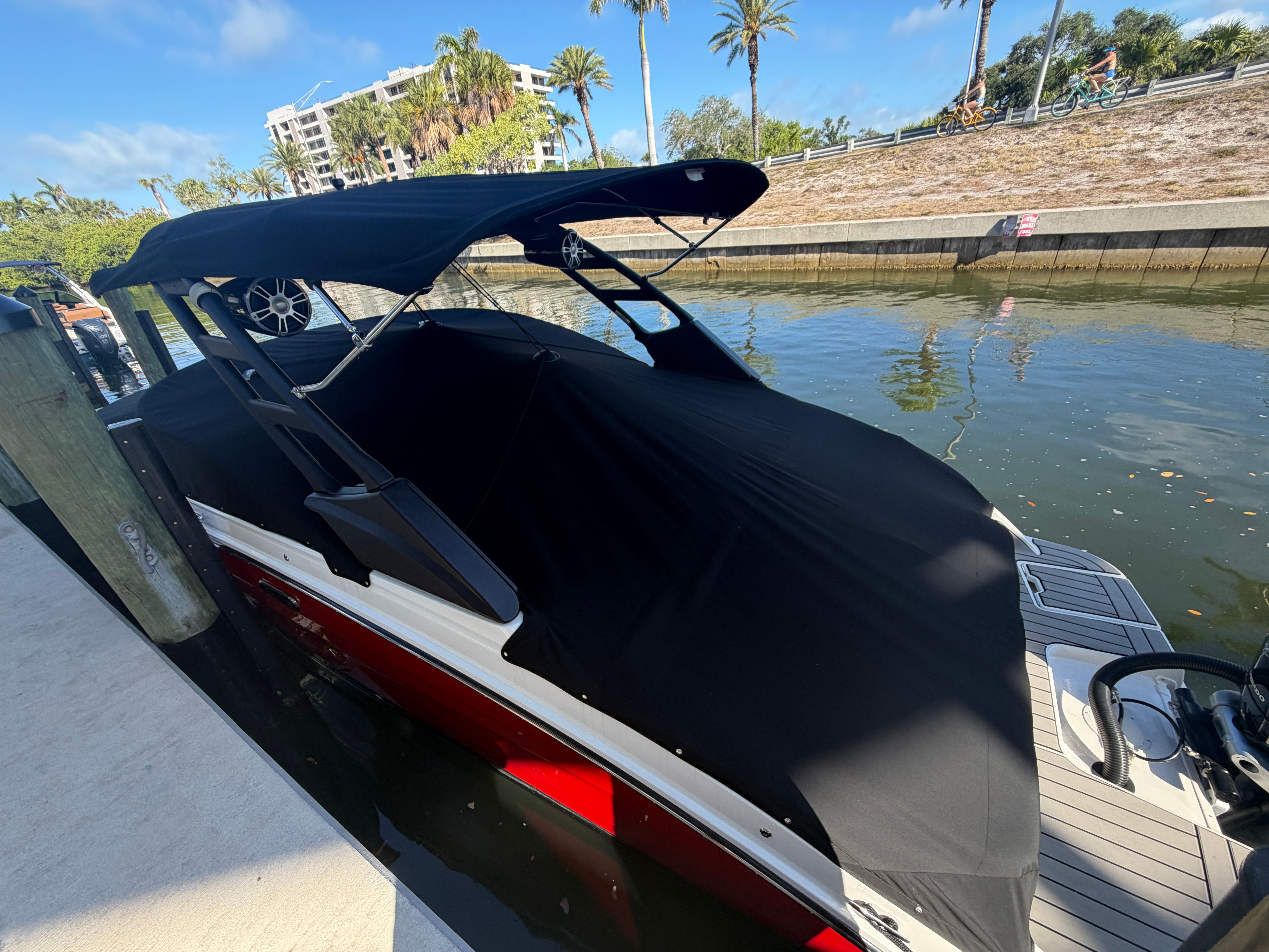A 2025 Sea Ray SDX 250 Outboard docked. It features a black canopy.