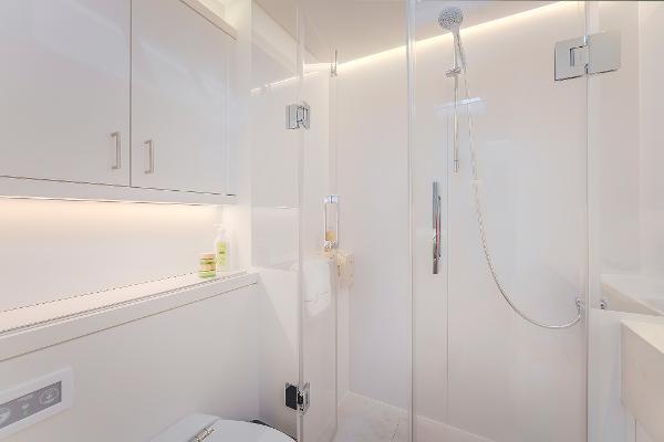 Modern bathroom in 2025 Lagoon SIXTY 5 yacht with sleek shower and cabinetry.