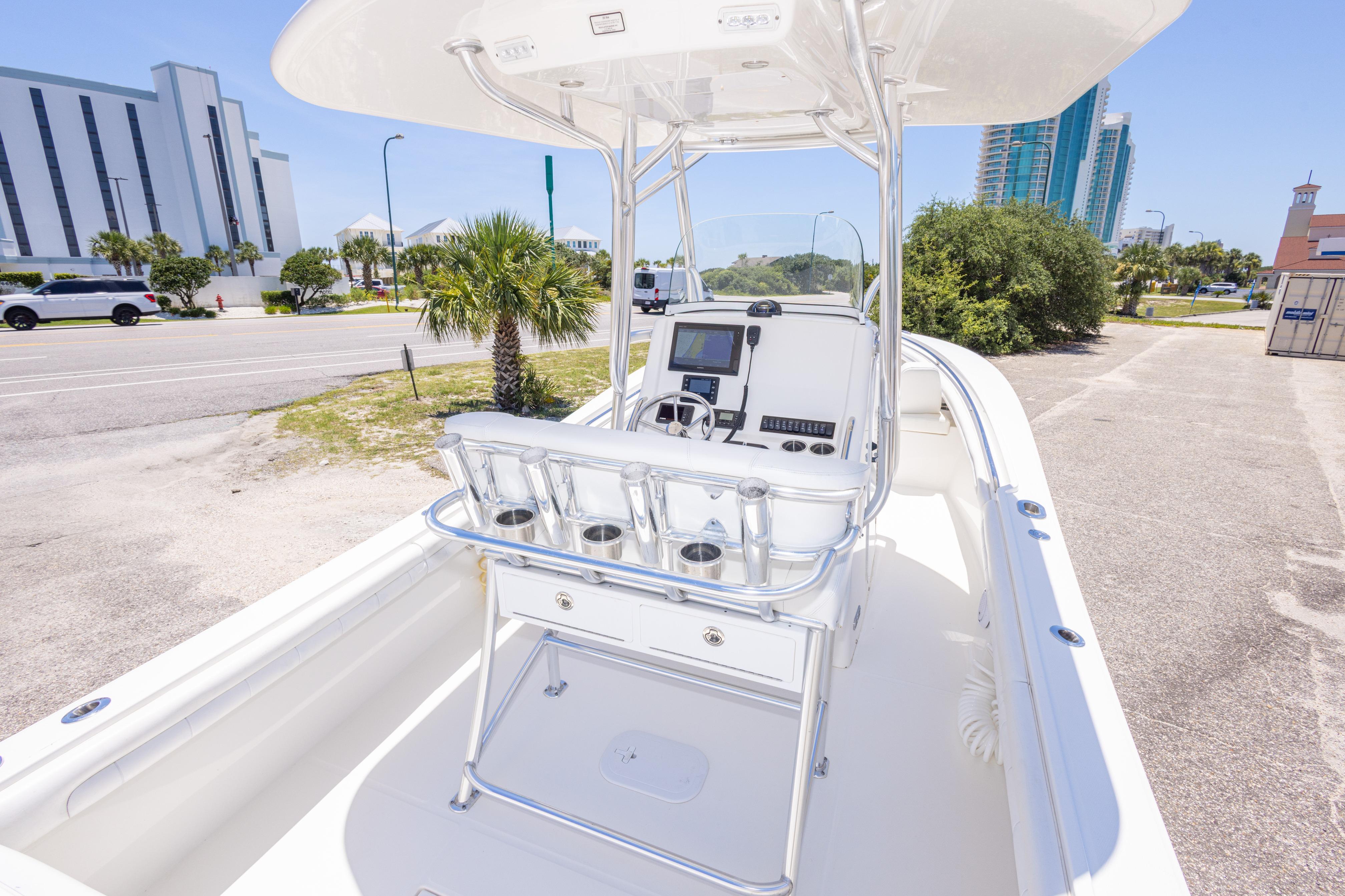 2019 Regulator 23 Center Console boat docked near a coastal road with palm trees.