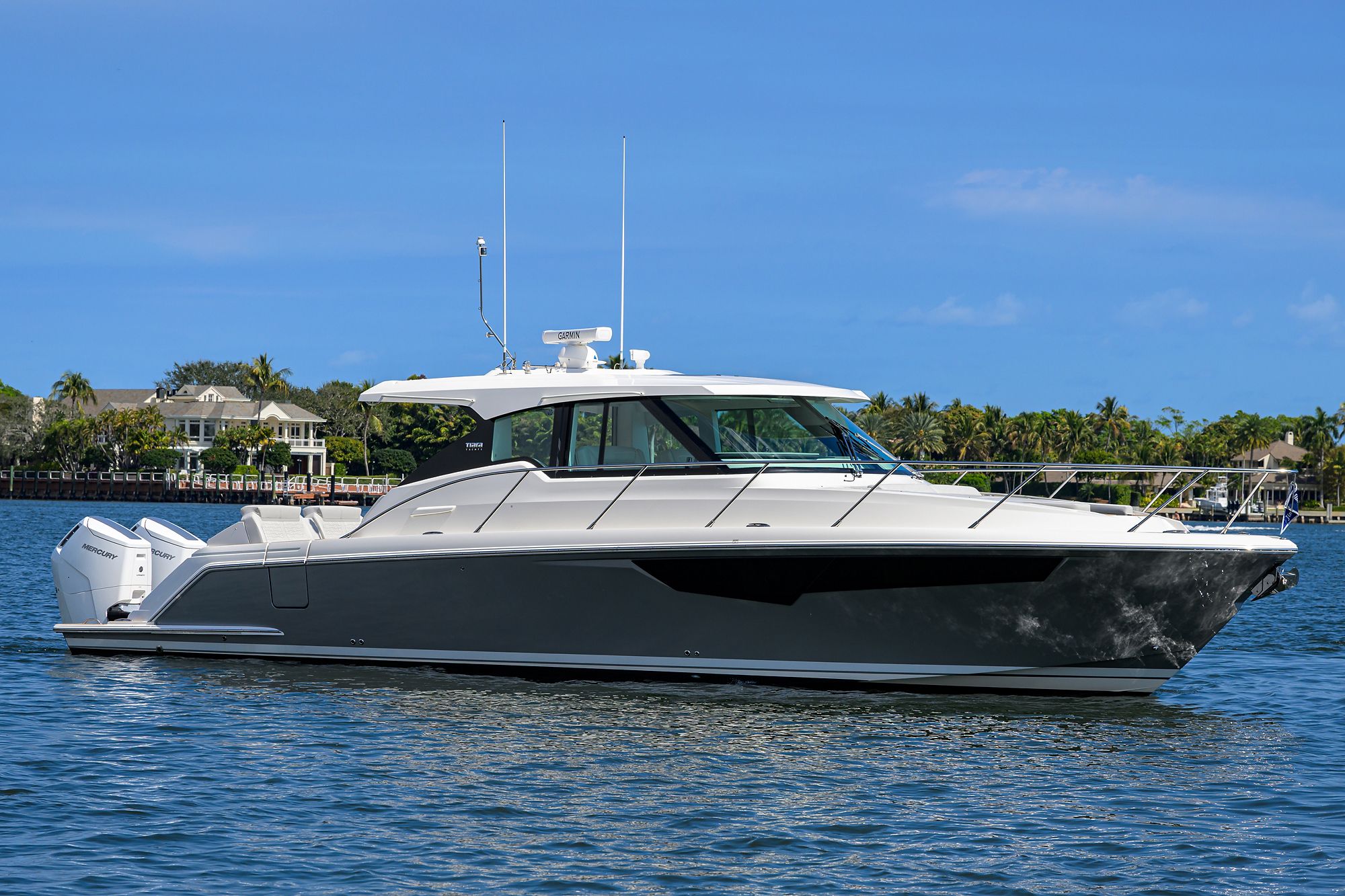 A luxury motor yacht on calm water with a clear sky in the background.
