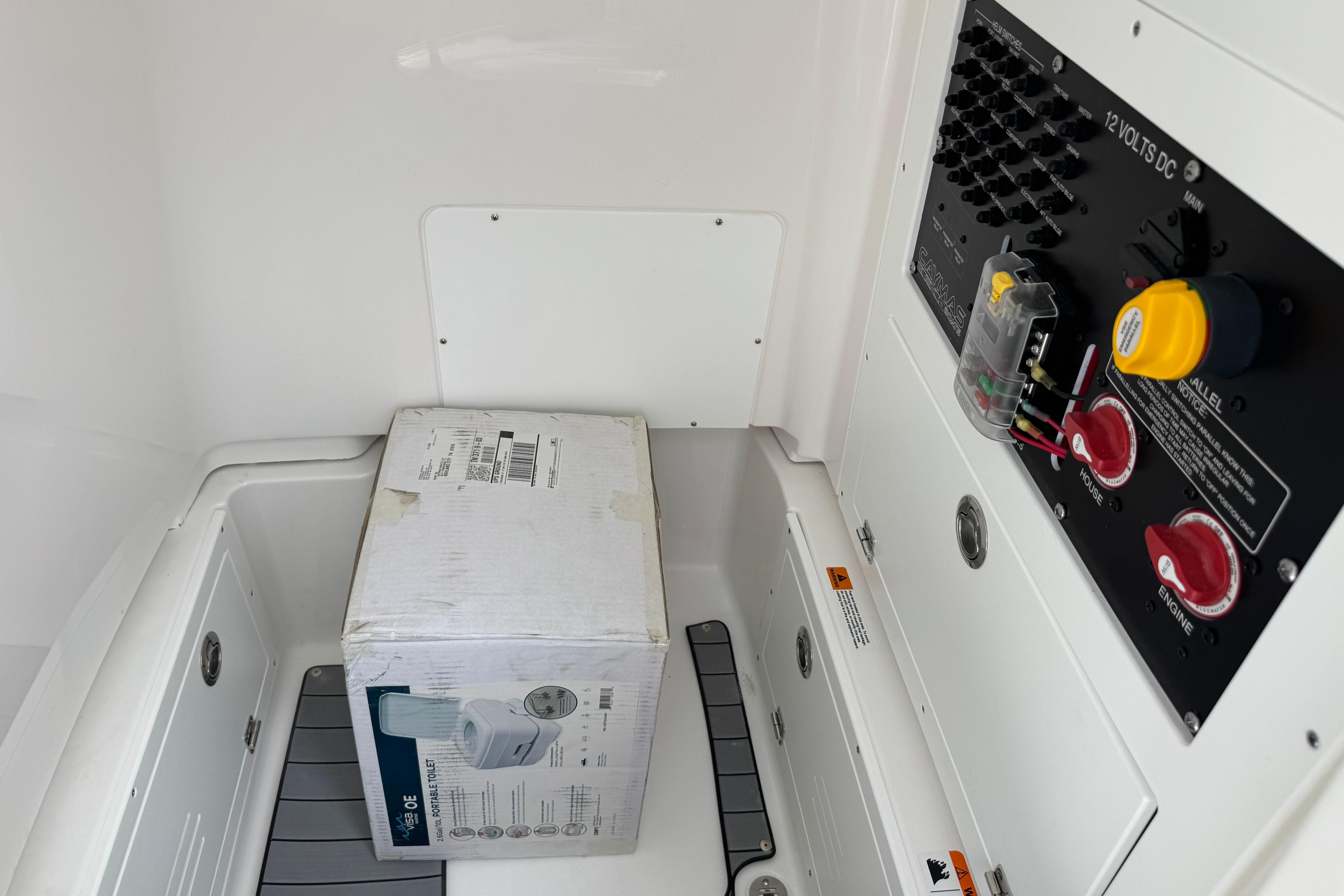Interior of 2027 Caymas 26 HB boat showing electrical panel and packaged item.