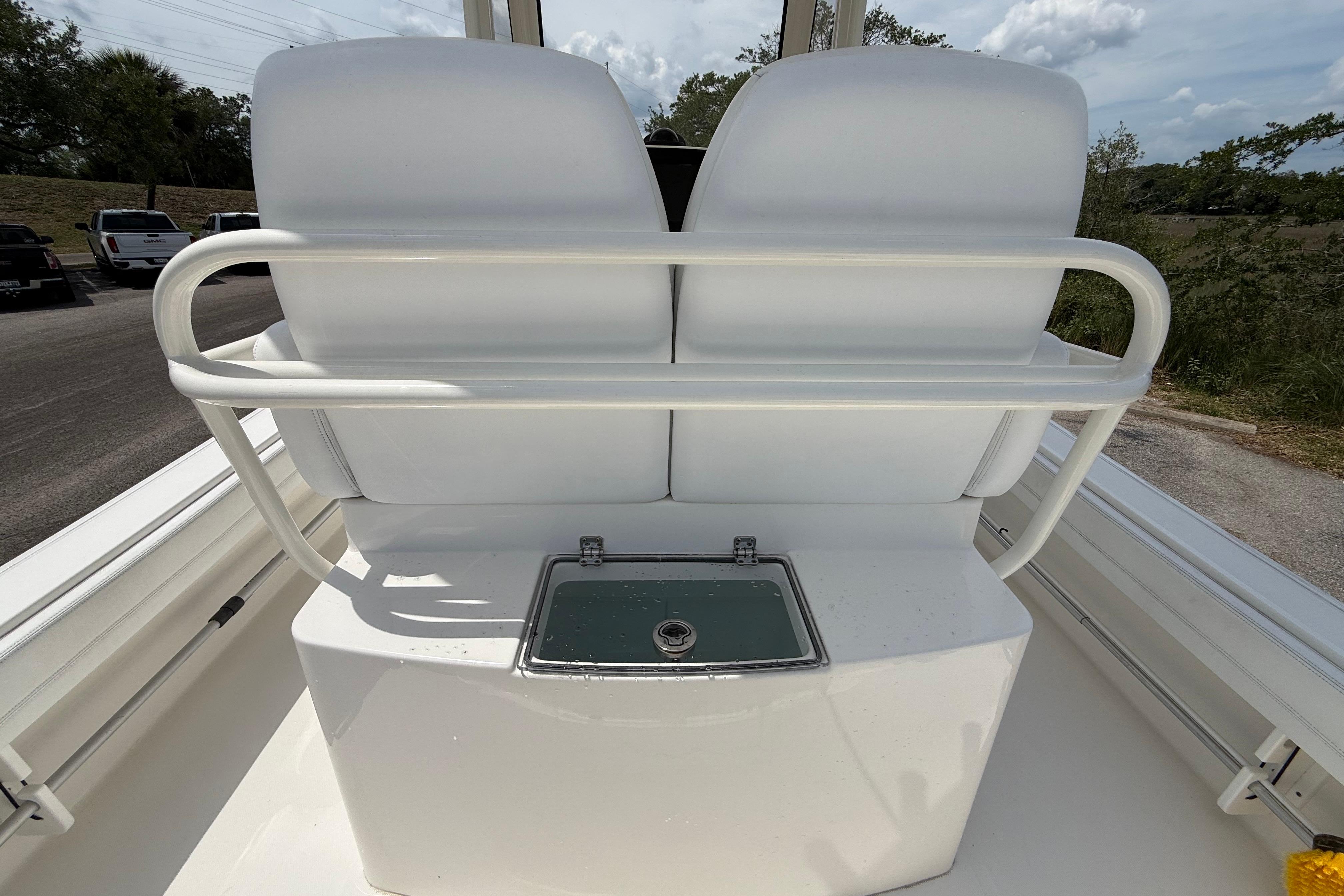 2019 Regulator 26XO boat seating with storage compartment, white upholstery, and railing.