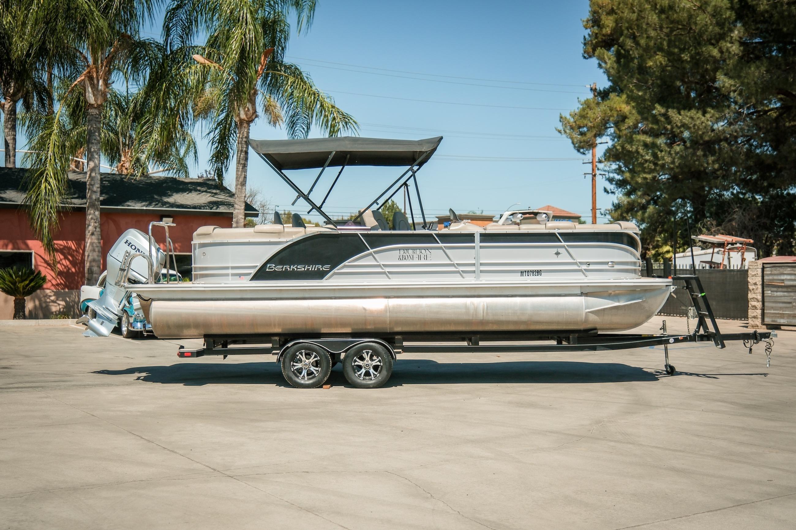 2019 Berkshire 25CLE STS pontoon boat on trailer, parked outdoors with palm trees.