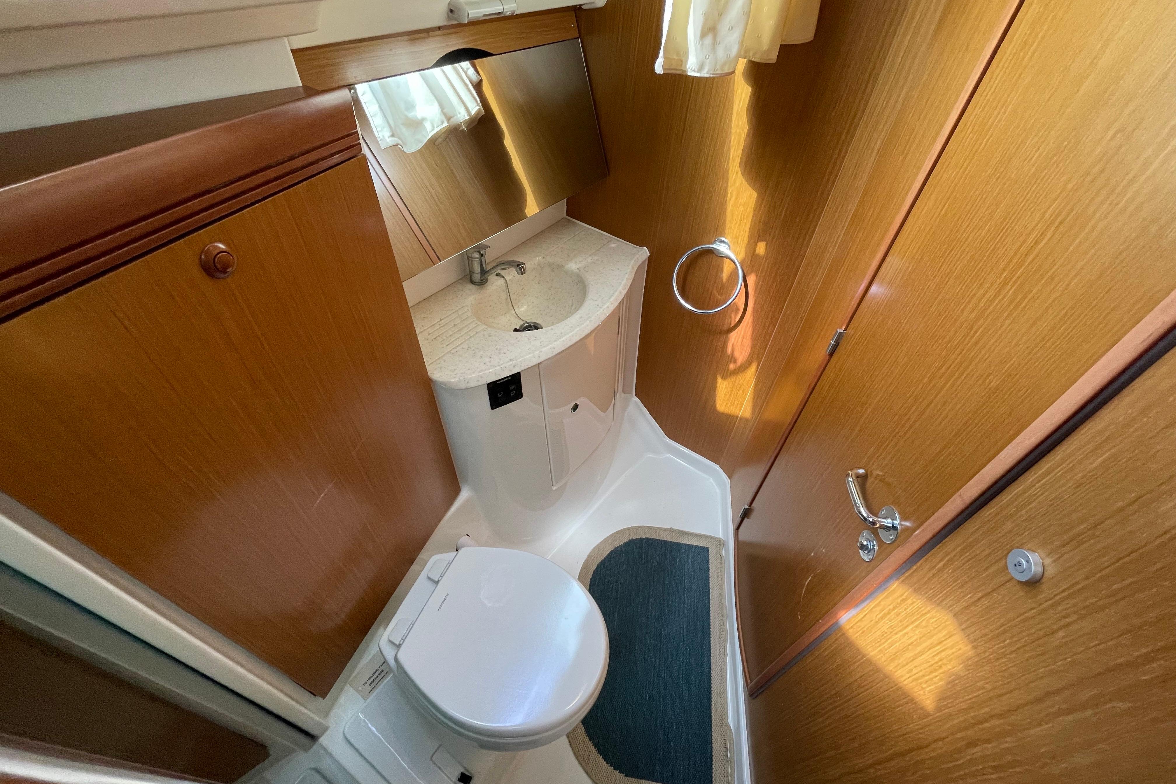 Bathroom interior of 2007 Jeanneau Sun Odyssey 39 DS yacht, featuring wood paneling and compact design.