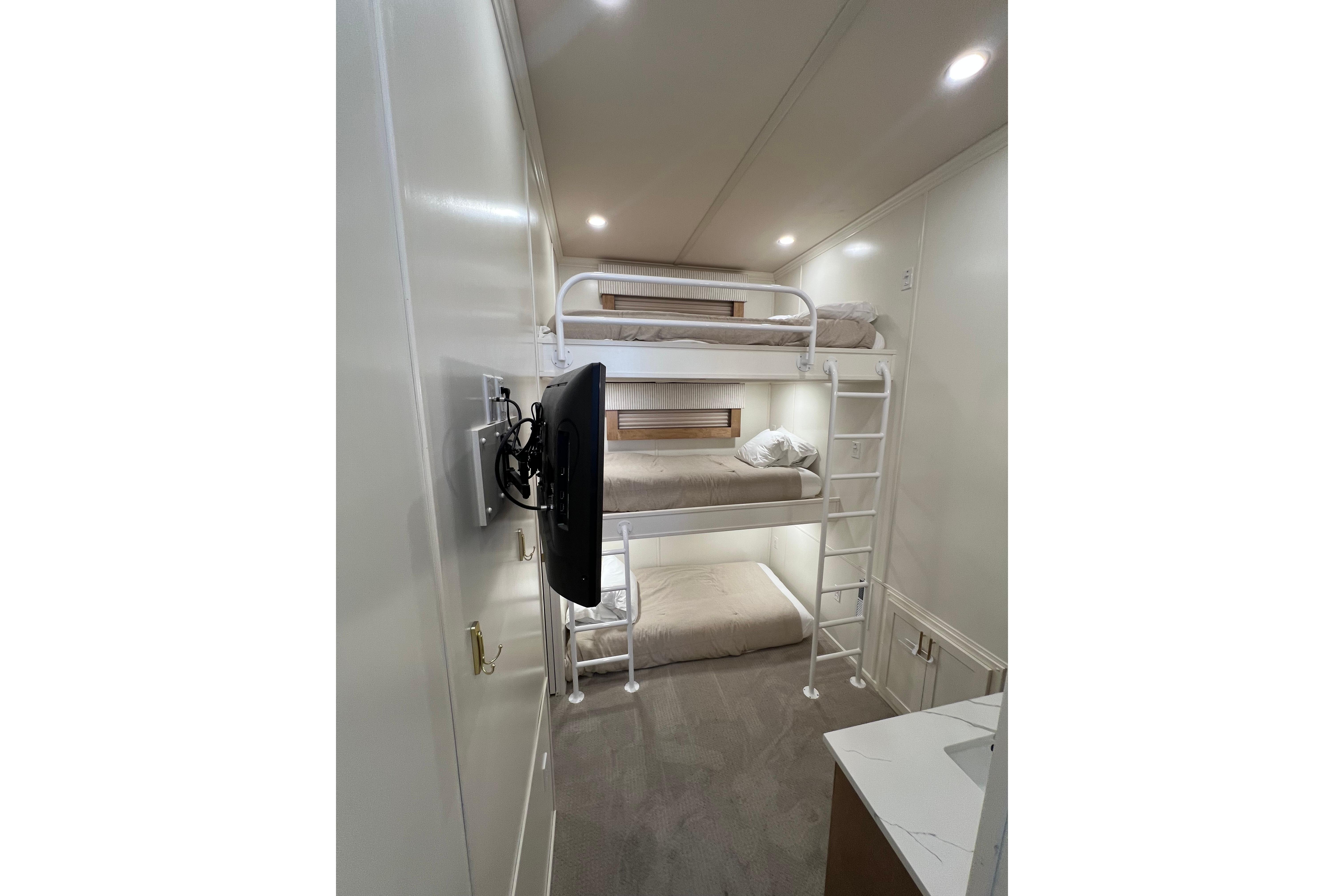 Bunk beds in a modern 2025 Sumerset Excellence Multiple Shares interior with mounted TV.