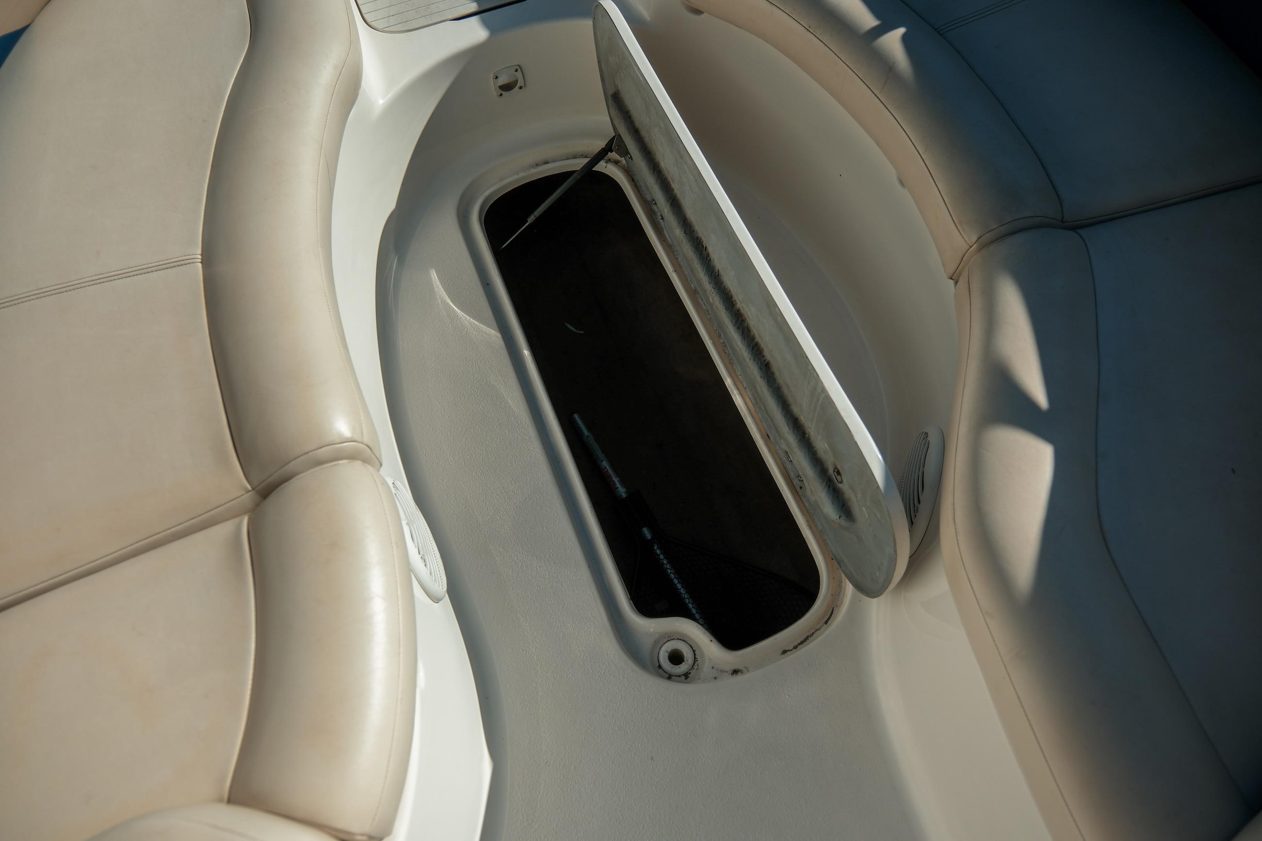 1998 Chaparral 232 Sunesta boat interior storage compartment with open hatch.