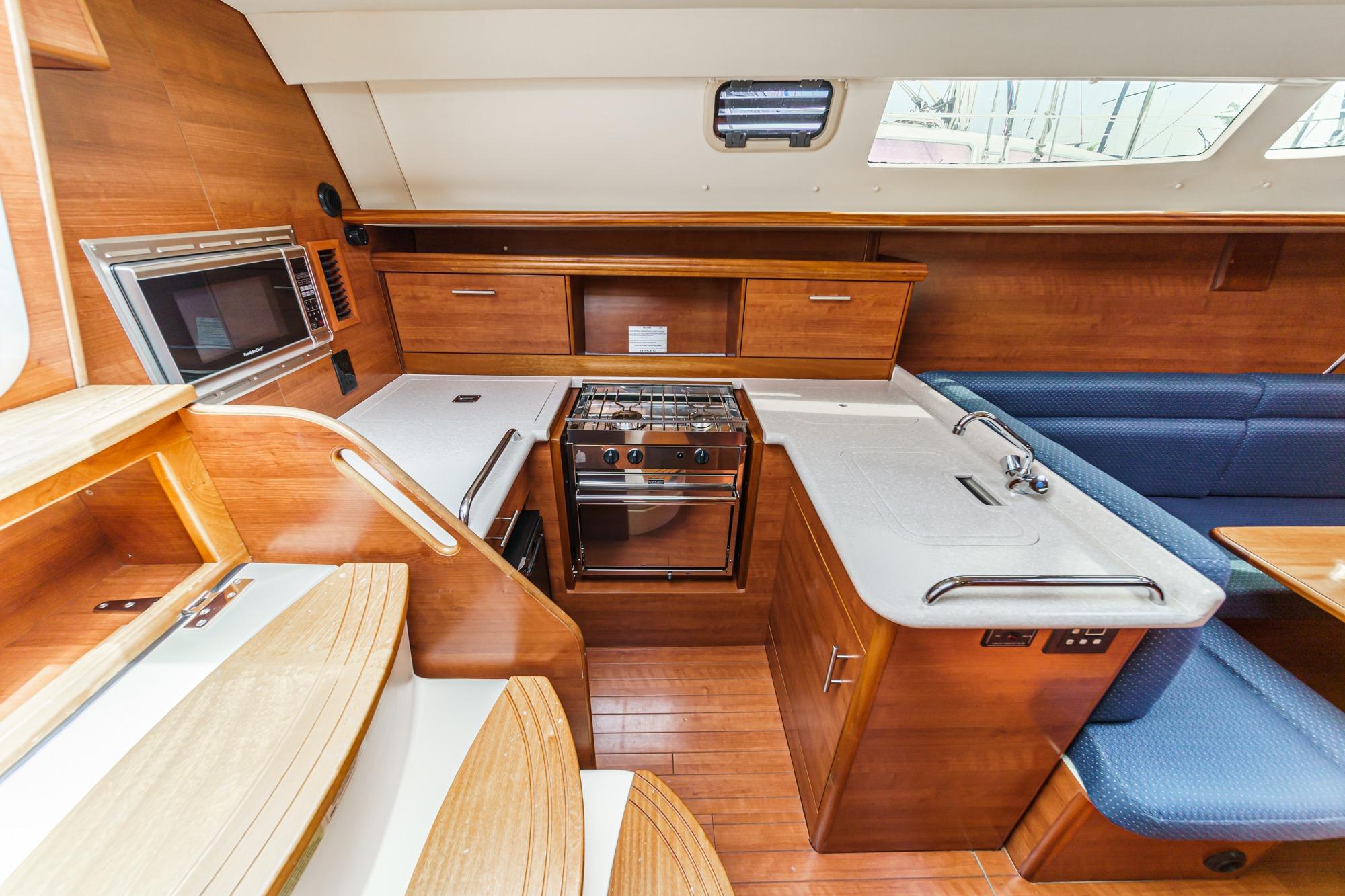 Interior of 2015 Hunter 33 sailboat featuring modern kitchen and seating area.