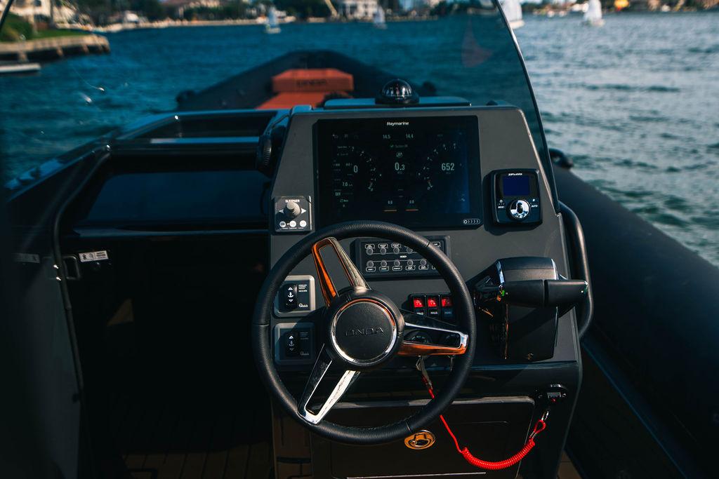2025 Onda Magna boat dashboard with steering wheel and navigation controls on the water.