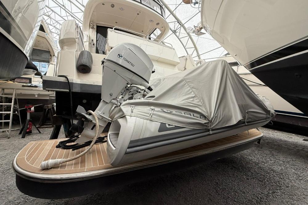 2007 Marquis 55 LS yacht with covered dinghy and Tohatsu outboard motor in storage.
