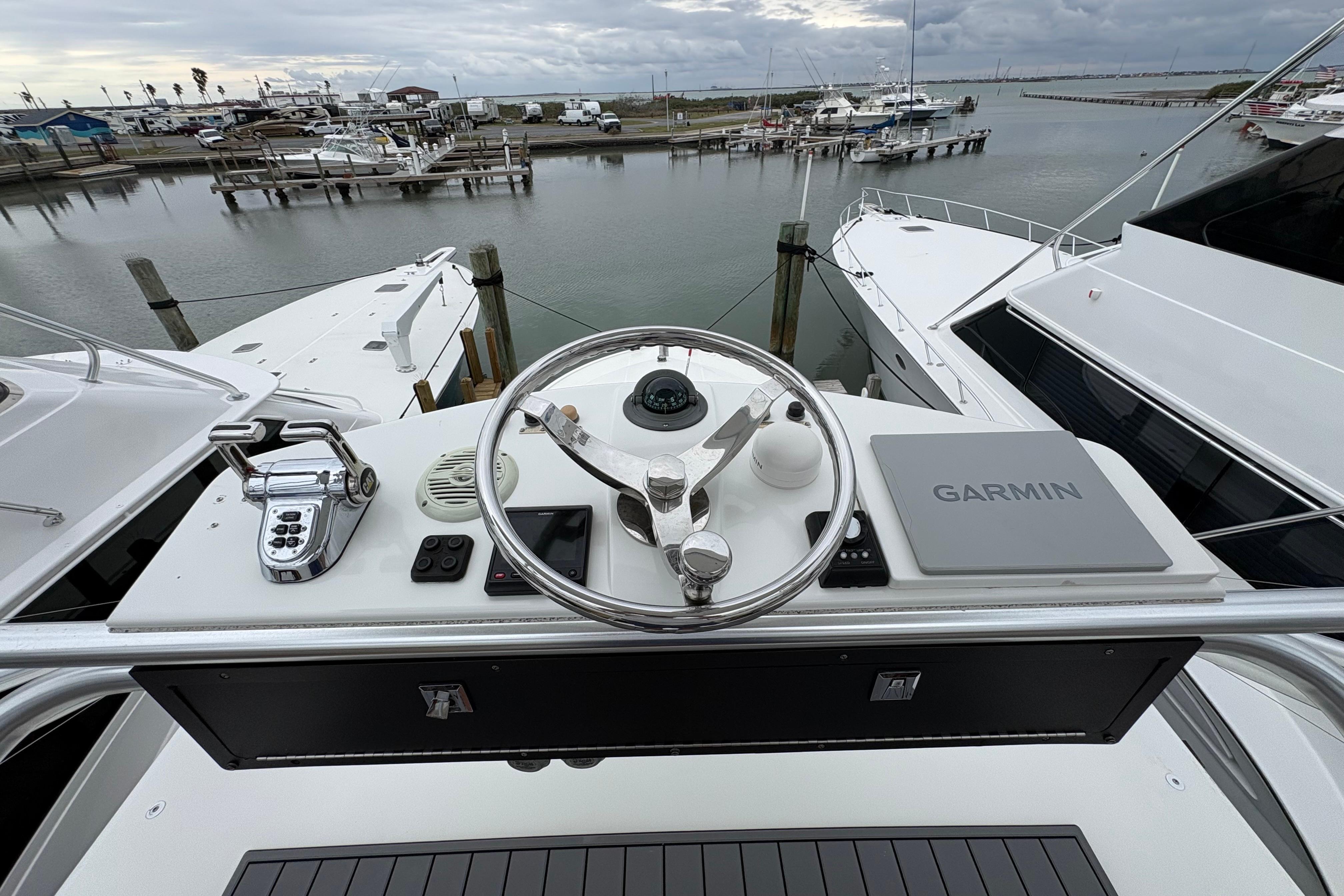 Helm of 2004 Cabo 40 Hardtop Express with Garmin navigation, docked at marina.